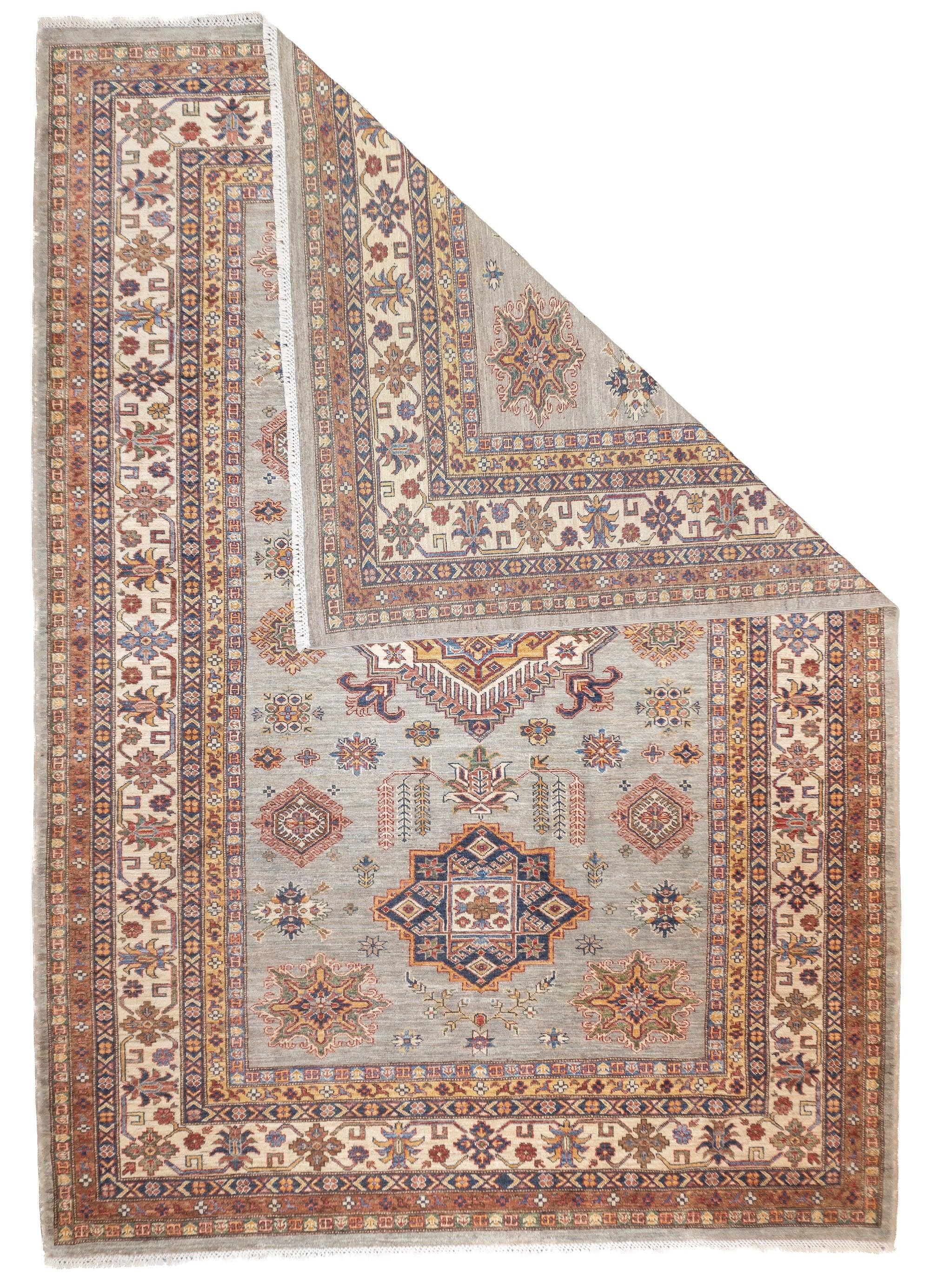 PAK Kazak Rug 6'9'' x 9'7''. Pakistani post-WWII rug, generally scatters, with soft wool and curvilinear Persianate designs. Synthetic dyes, cotton foundations. Moderate to medium weaves.
