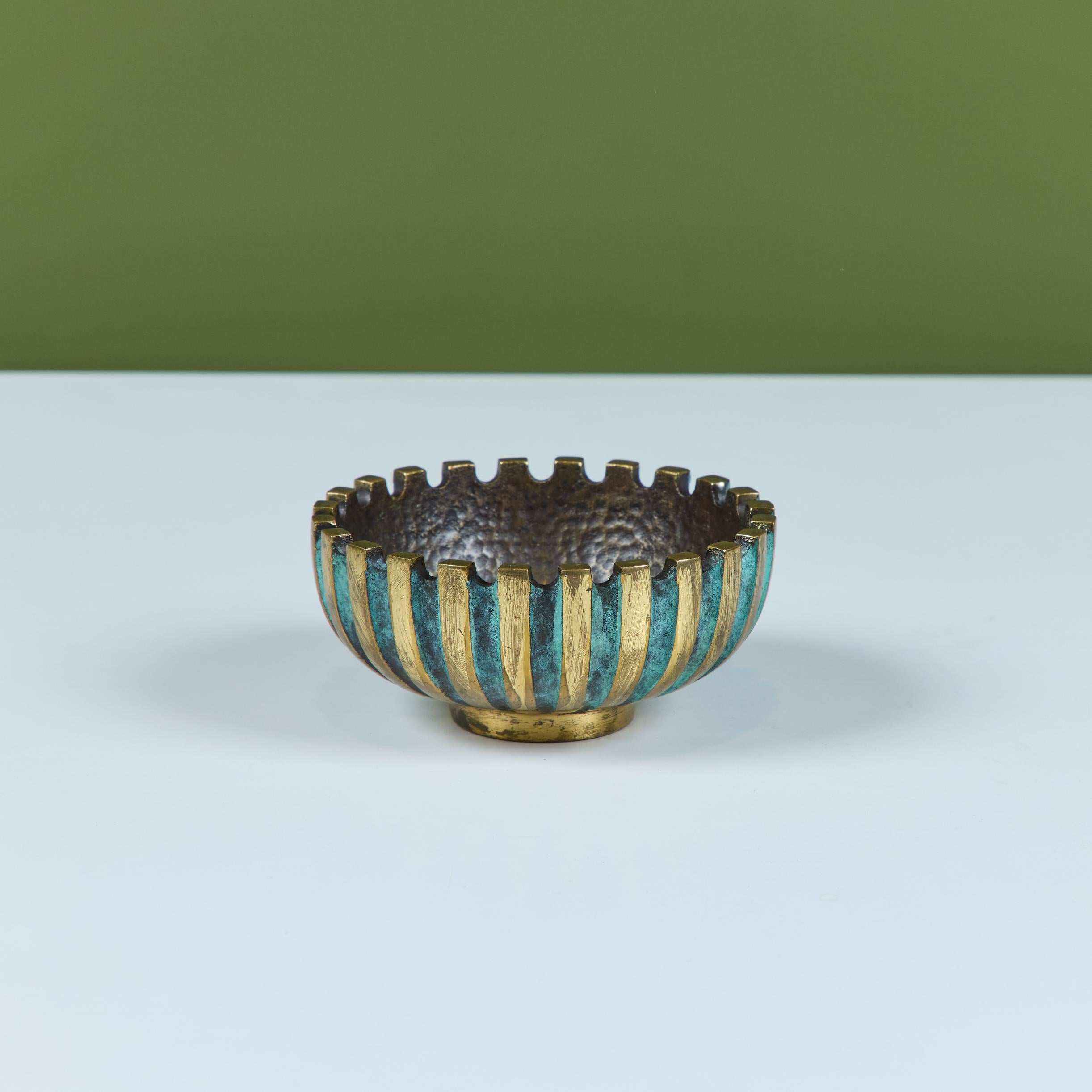 Cuenco Pal Bell de bronce fundido de mediados de siglo. Presenta un exterior dentado y estriado con franjas alternas de bronce patinado y verdigris. El interior tiene una textura martillada a mano. Un sello en relieve en la parte inferior reza