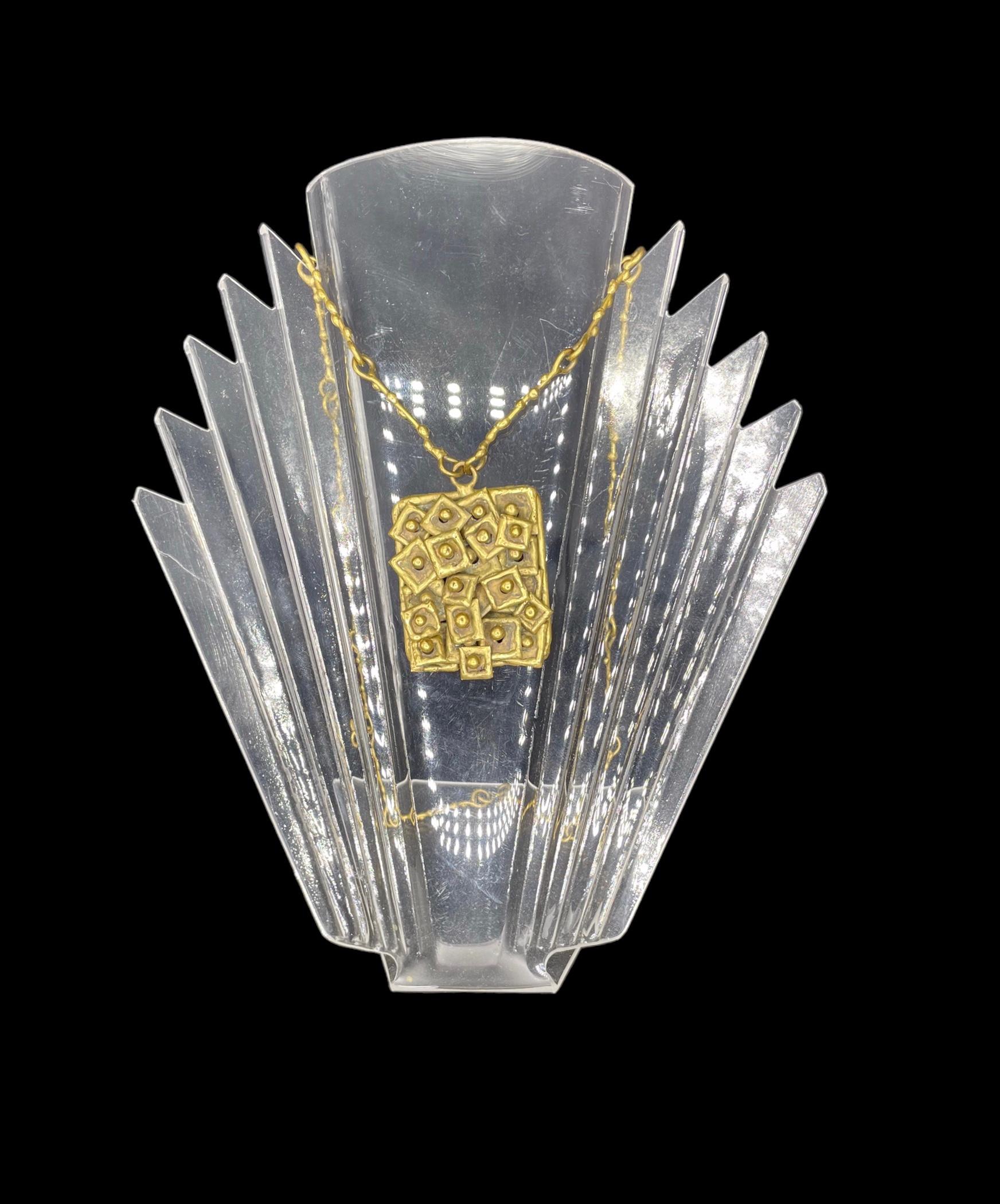 Conçu par Pal Kepenyes (1926-2021), ce collier brutaliste est réalisé en laiton, avec une patine naturelle vieillie.  Il est décoré de carreaux qui se chevauchent, ce qui donne à cette pièce artisanale une impression de mouvement. La chaîne