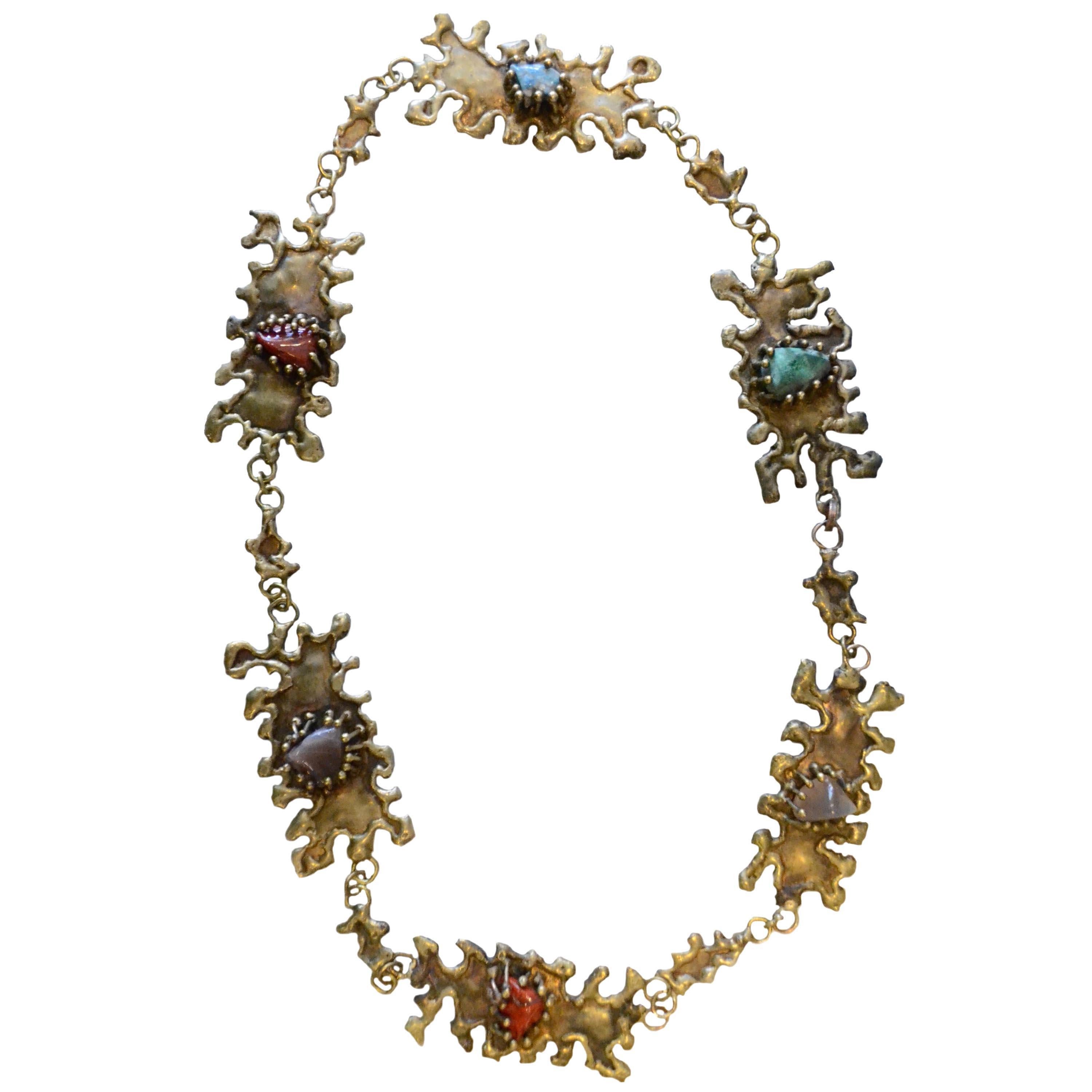 A gorgeous Brutalist bronze necklace with semiprecious stones by Pal Kepenyes. The necklace with 6 organic-shaped medals and 6 irregular semiprecious stones set by needle-shaped claws. Sealed in the back of one of the medals.

Chain's length: 82