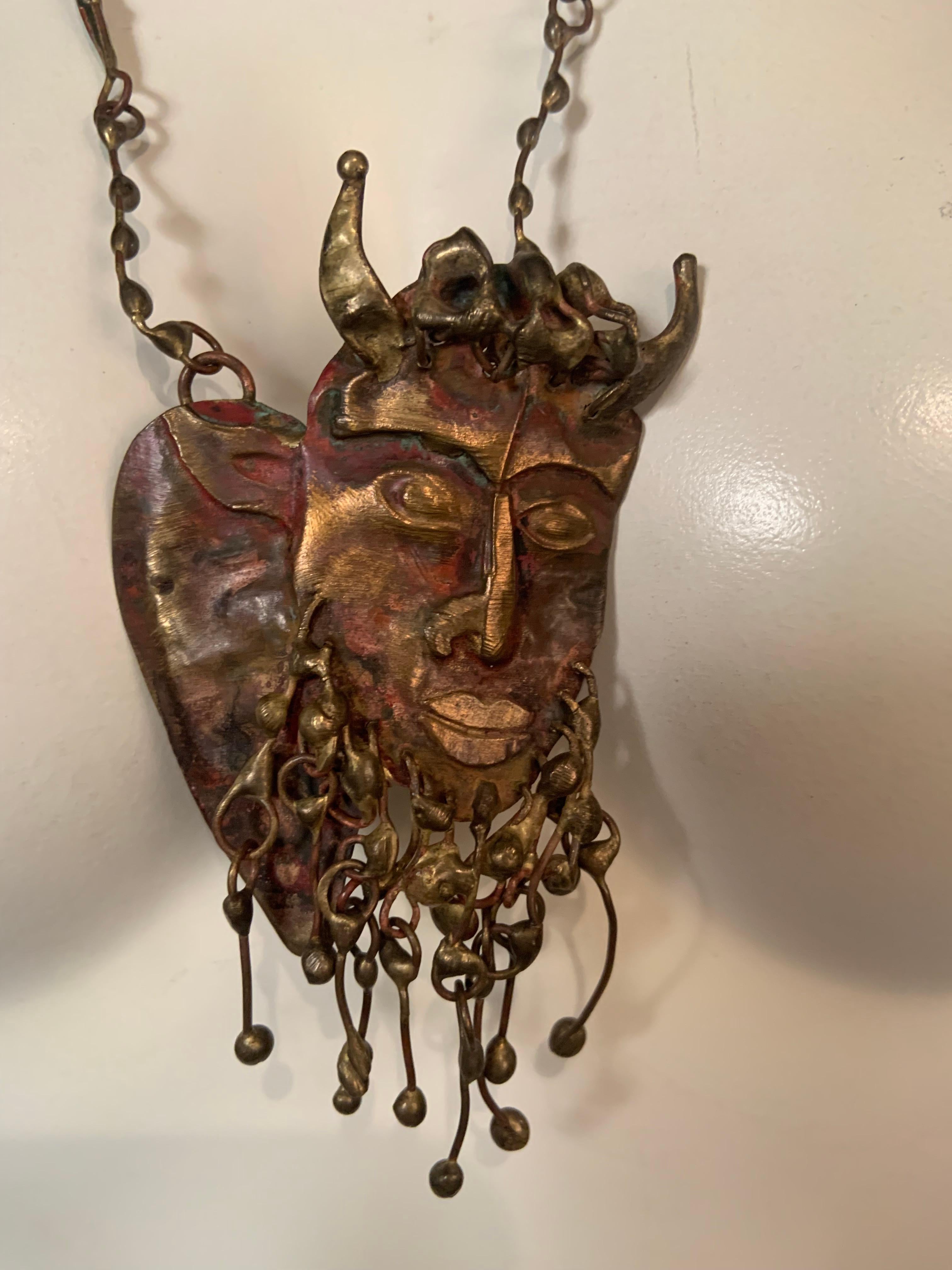 Pal Kepenyes has created a hand made and striking image of a horned Satyr with a kinetic beard rendered in brass and bronze in the Brutalist manner.  It is suspended frpm a hand made chain and it is in excellent condition.  This piece is also from