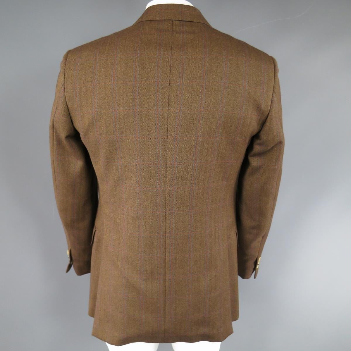 Classic PAL ZILERI two button sport coat in a light brown harringbone textured wool with all over blue and red windowpane print. Detailed with a top stitch peak lapel, flap pockets, functional button cuffs, and double vented back. Made in