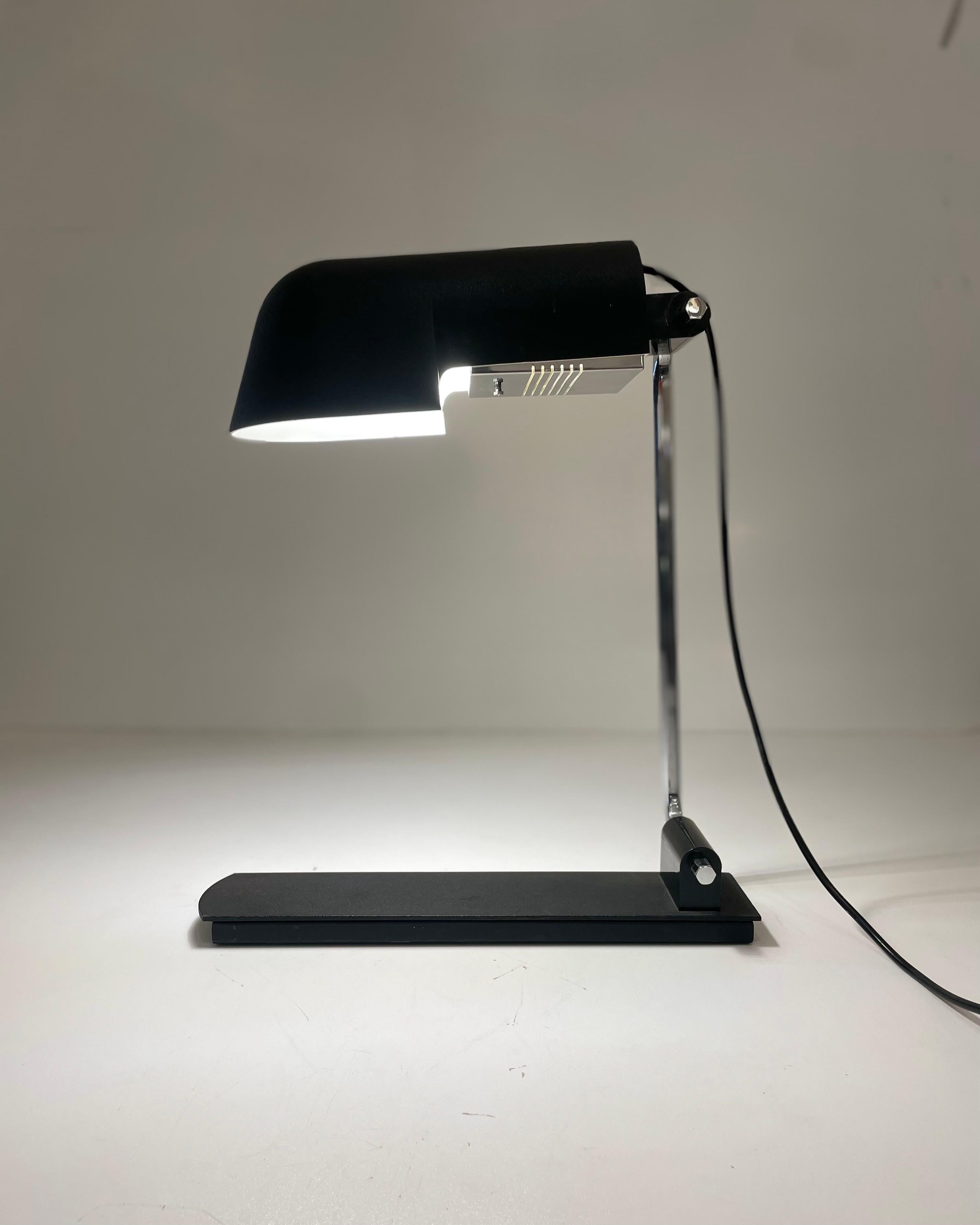 Italian desk or table lamp, made of black painted metal with a chrome-plated steel rod. Using a uniq system the lamp is adjustable to your need and lighting ambiance. Named Pala, this 490 model was designed by the brother Corrado et Luigi Aroldi for