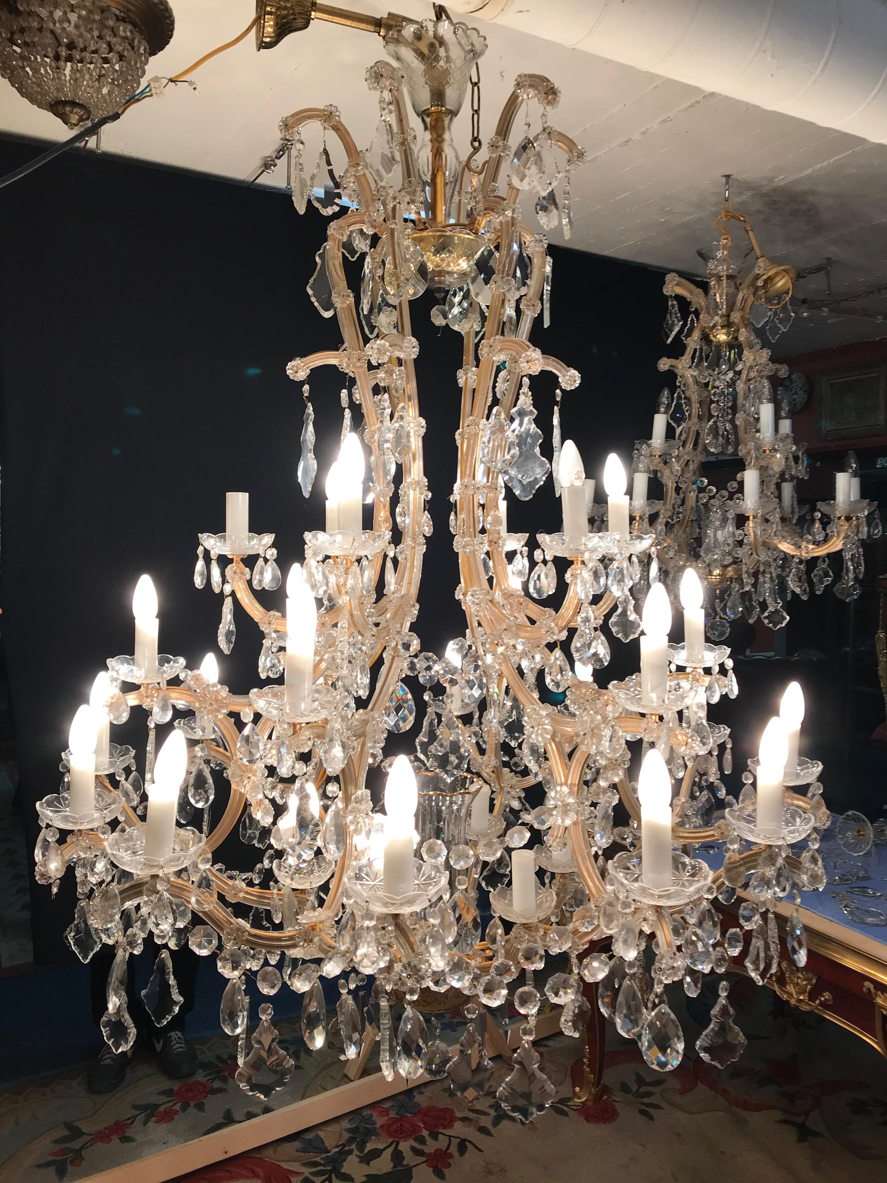Un lustre de style baroque très étonnant et rare. Corps ajouré de forme balustre. Au centre, de multiples balustres articulés, en verre taillé incolore, se fondent en une couronne en forme de cloche. Bras de chandelier correspondants avec 36 lampes