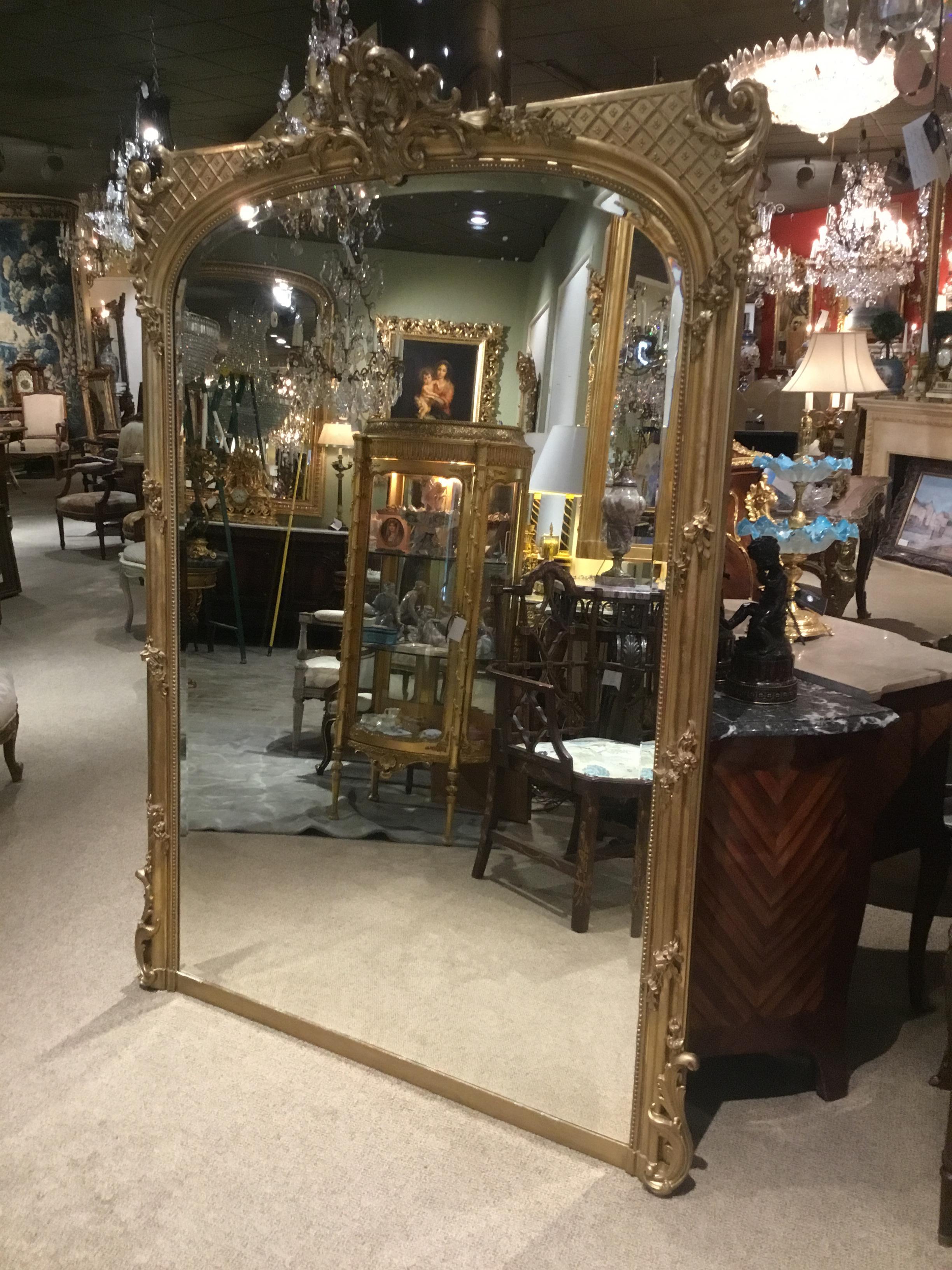 Large and beautiful Louis XV-style giltwood framed mirror with beveled plate..
Shell cartouche is centered at the crest with exquisite scrolls that surround the
Cartouche. The top of the mirror is gracefully curved and the upper corners
Have