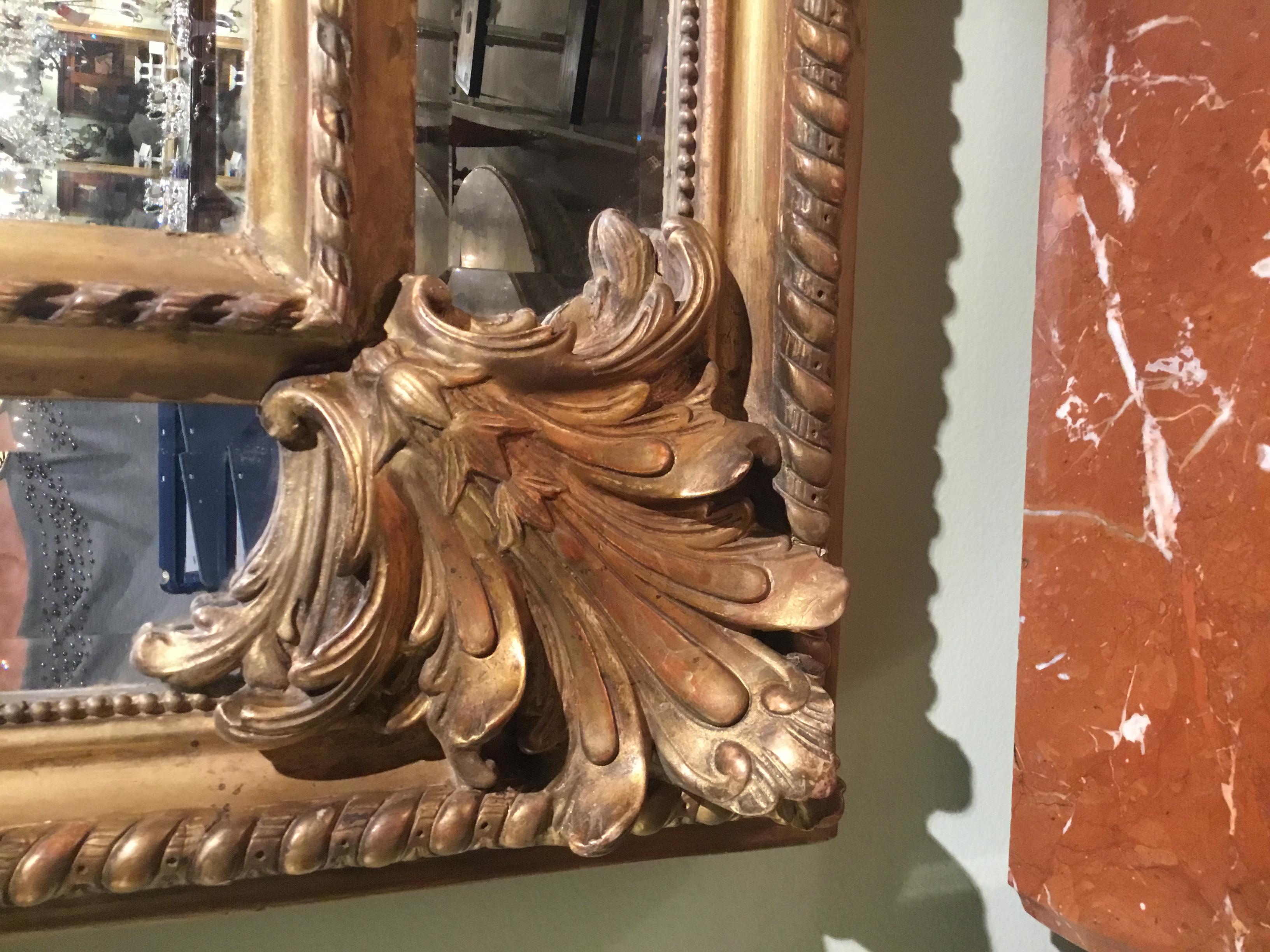 Exceptional and special mirror with elaborate design in the Rococo style.
Giltwood hand carved with large swirling pattern at the crest, a rope design
surrounds the entire edge, it is double framed in the cushion manner. Each
corner has an