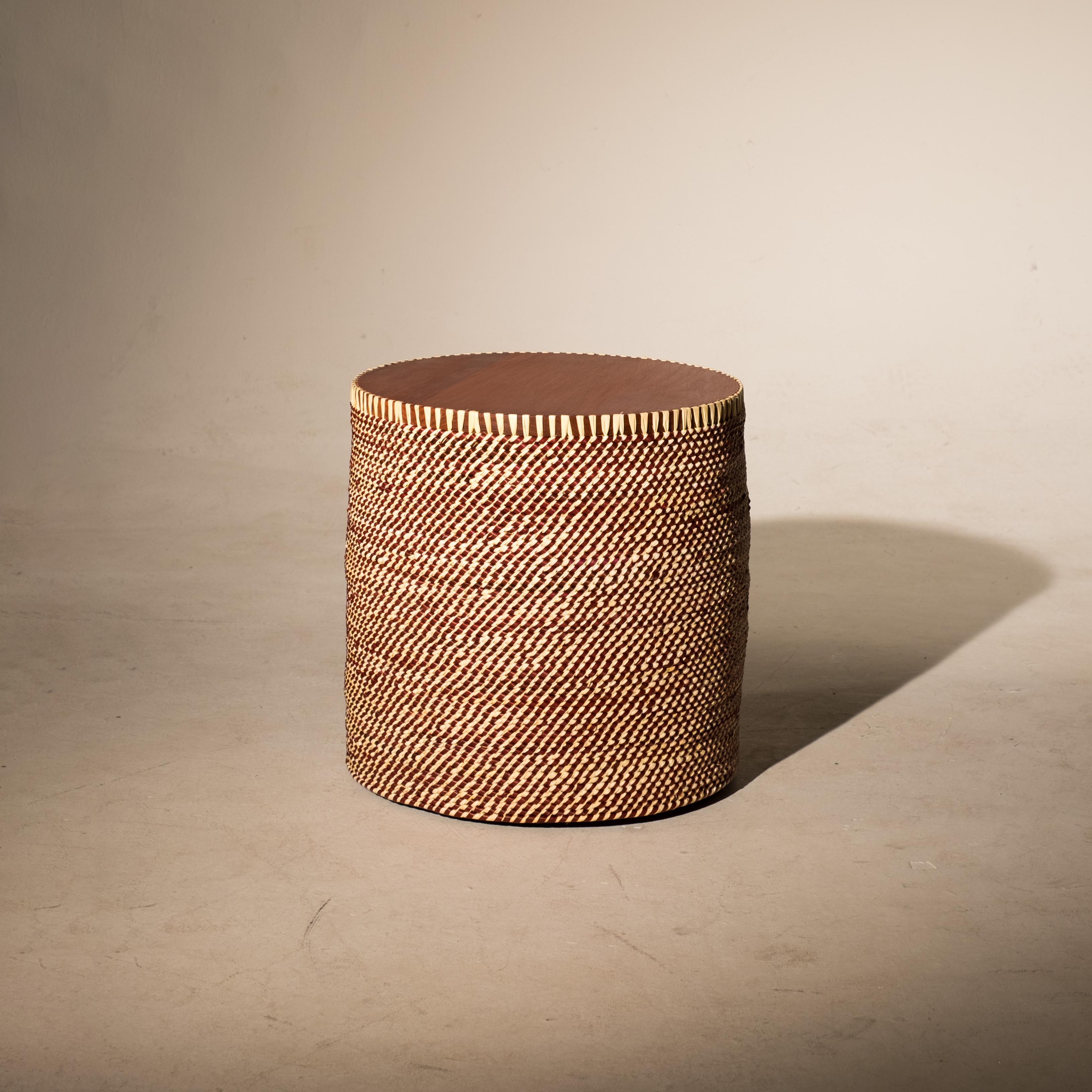 Palafitas side table is made of Imbuia or cabreuva wood and bring the Tucumã straw, a typical palm of the Amazon rainforest, stained with roots, leaves and fruits, and braided by the artisans of the riverside Community of Urucureá, in Pará.

Like