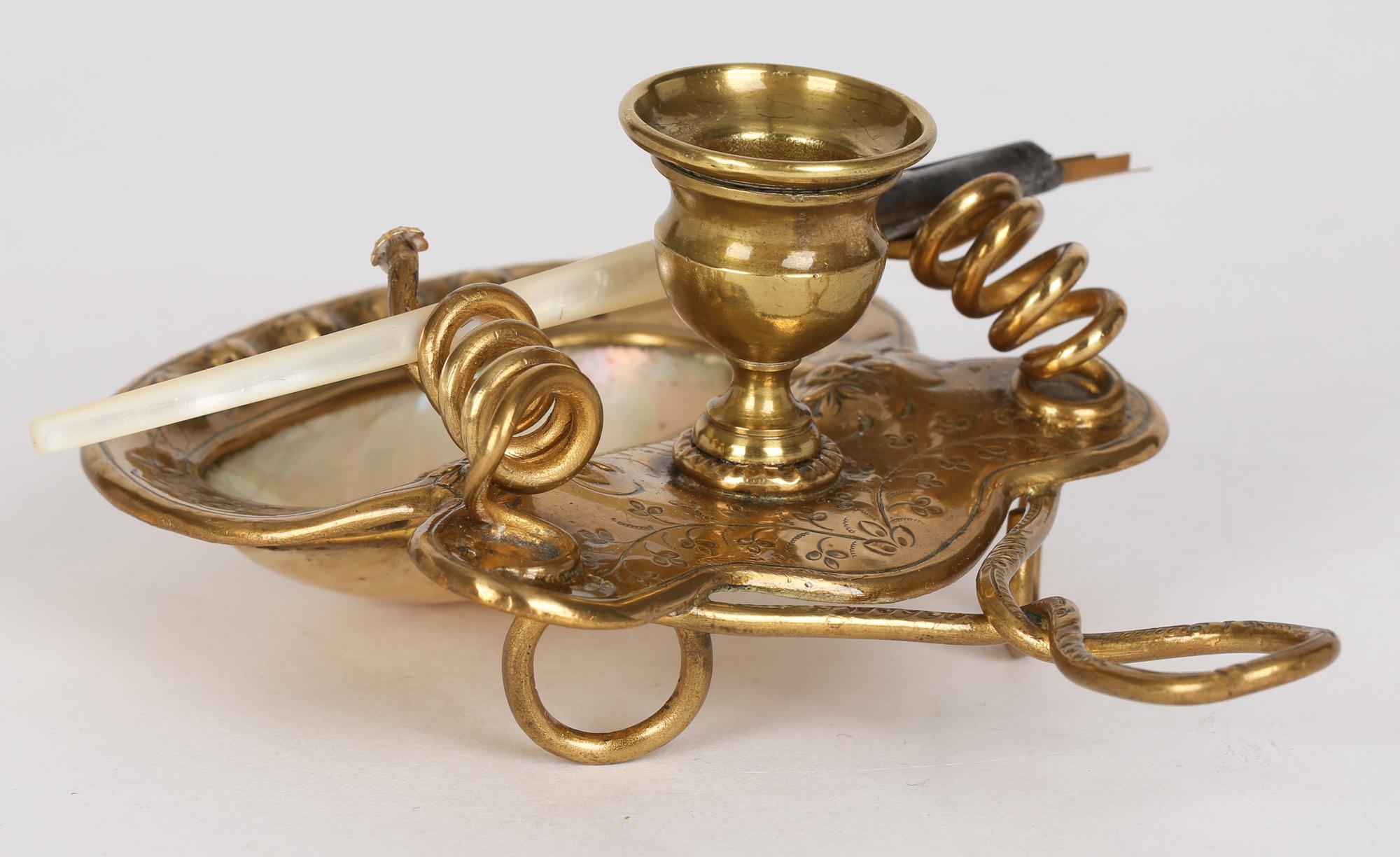 A very finely made antique French Palais Royal ormolu mounted mother of pearl desk stand with pen dating from around 1900. The stand comprises of an ornate looped wire work carrying handle with a candle holder mounted on a shaped metal body embossed