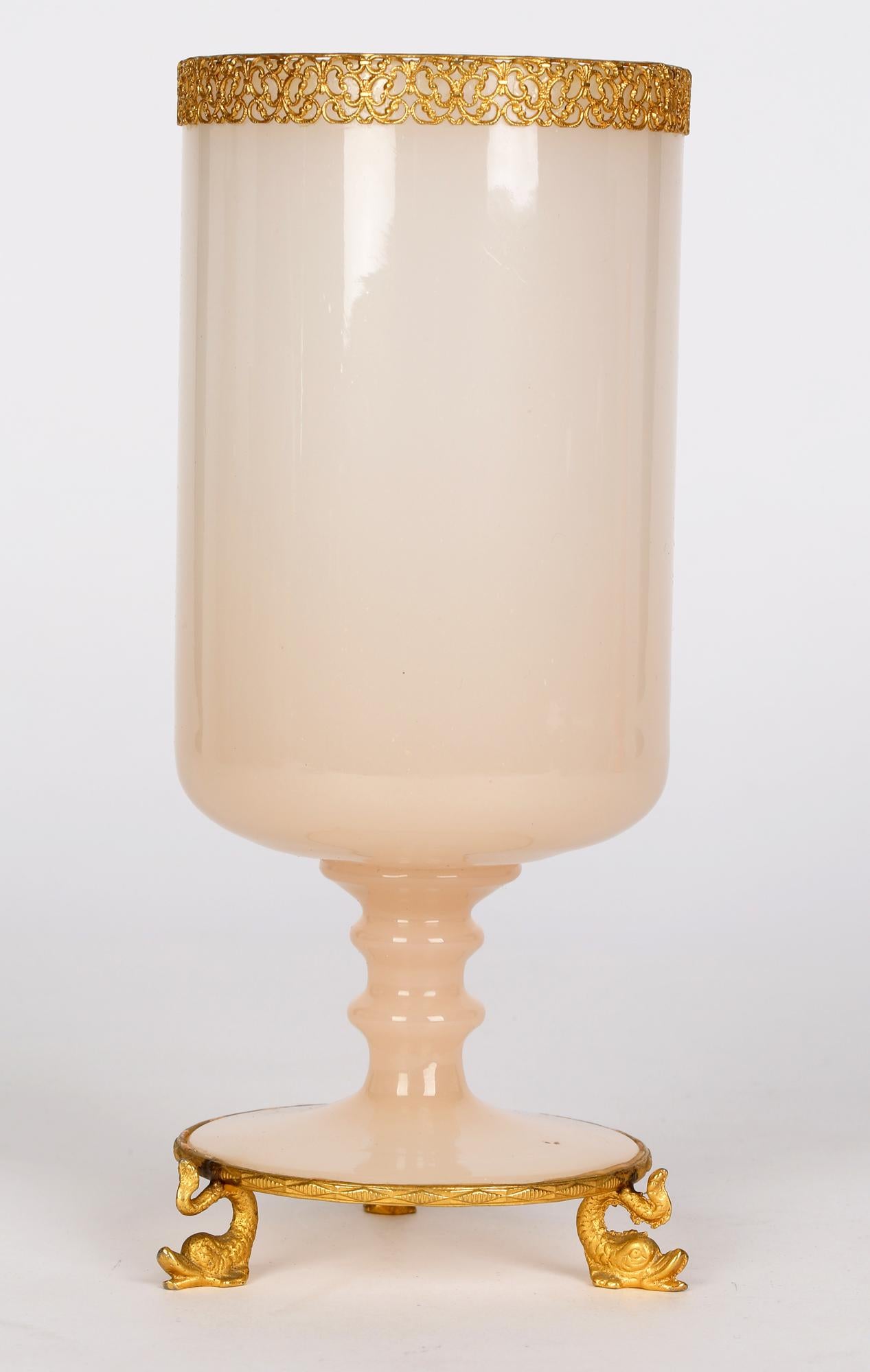 A very finely made antique French Palais Royal ormolu mounted pink opaline glass vase dating from around 1850. The pedestal vase is of cylindrical shape and possibly originates from Baccarat. It sits raised within an ormolu metal mount with three