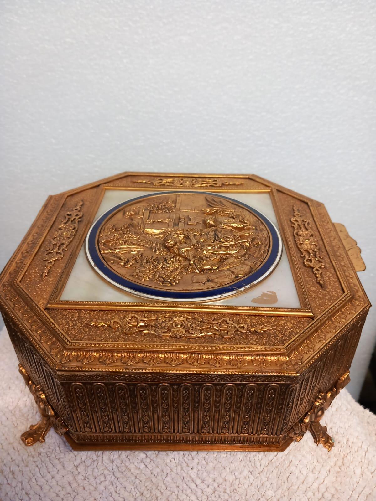 A very good quality and unusual Palais Royal gilt bronze and mother of pearl jewellery casket or trinket box dating from the first quarter of the nineteenth century. 
The box is in gilded bronze with a repoussé allegorical cartouches of a man