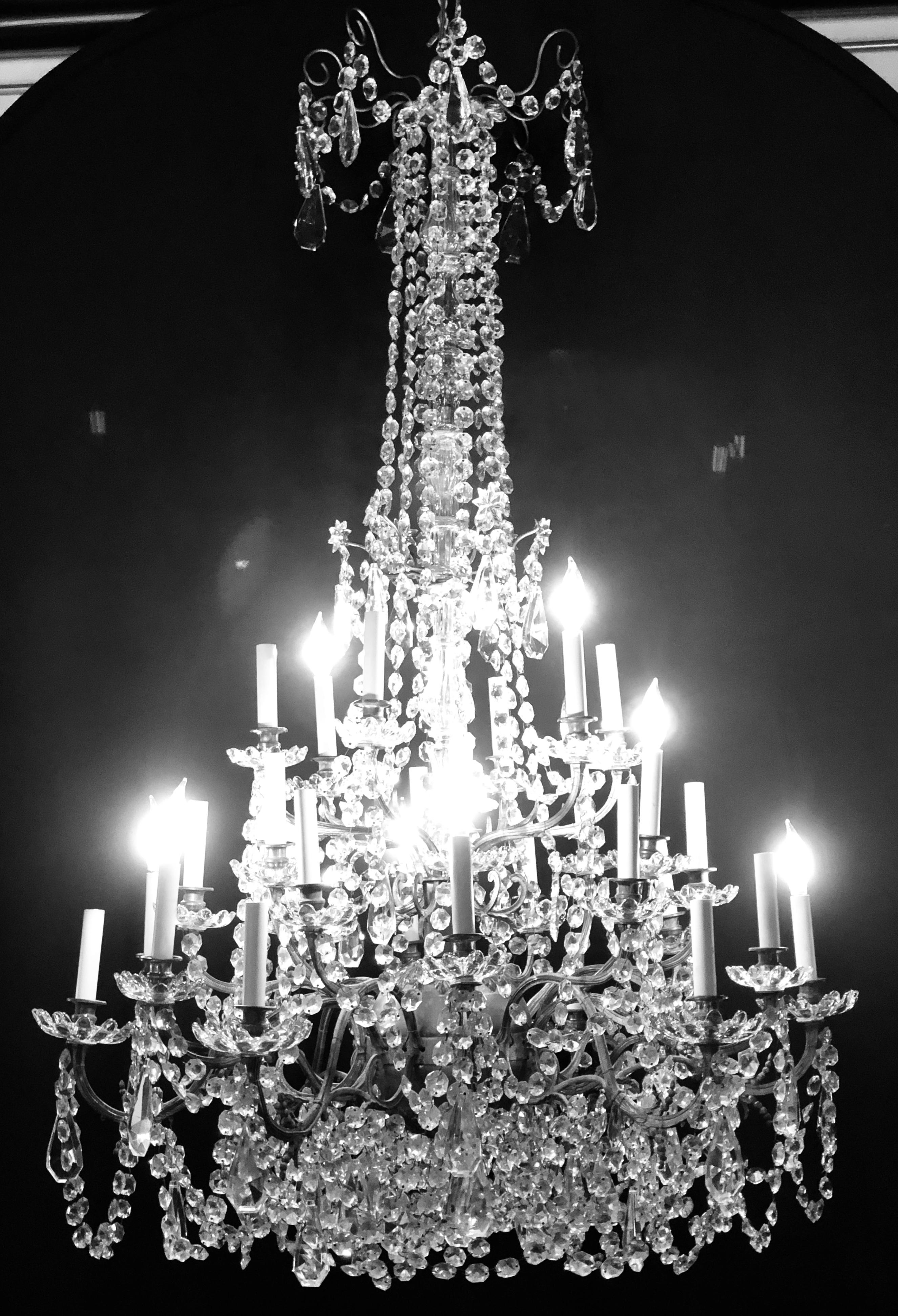 Palatial 19th or early 20th century thirty-light French crystal and brass column-form chandelier. This spectacular fixture has a central circular sphere that has a myriad of flowing gleaming cut crystals sprouting from the centre. The centre support