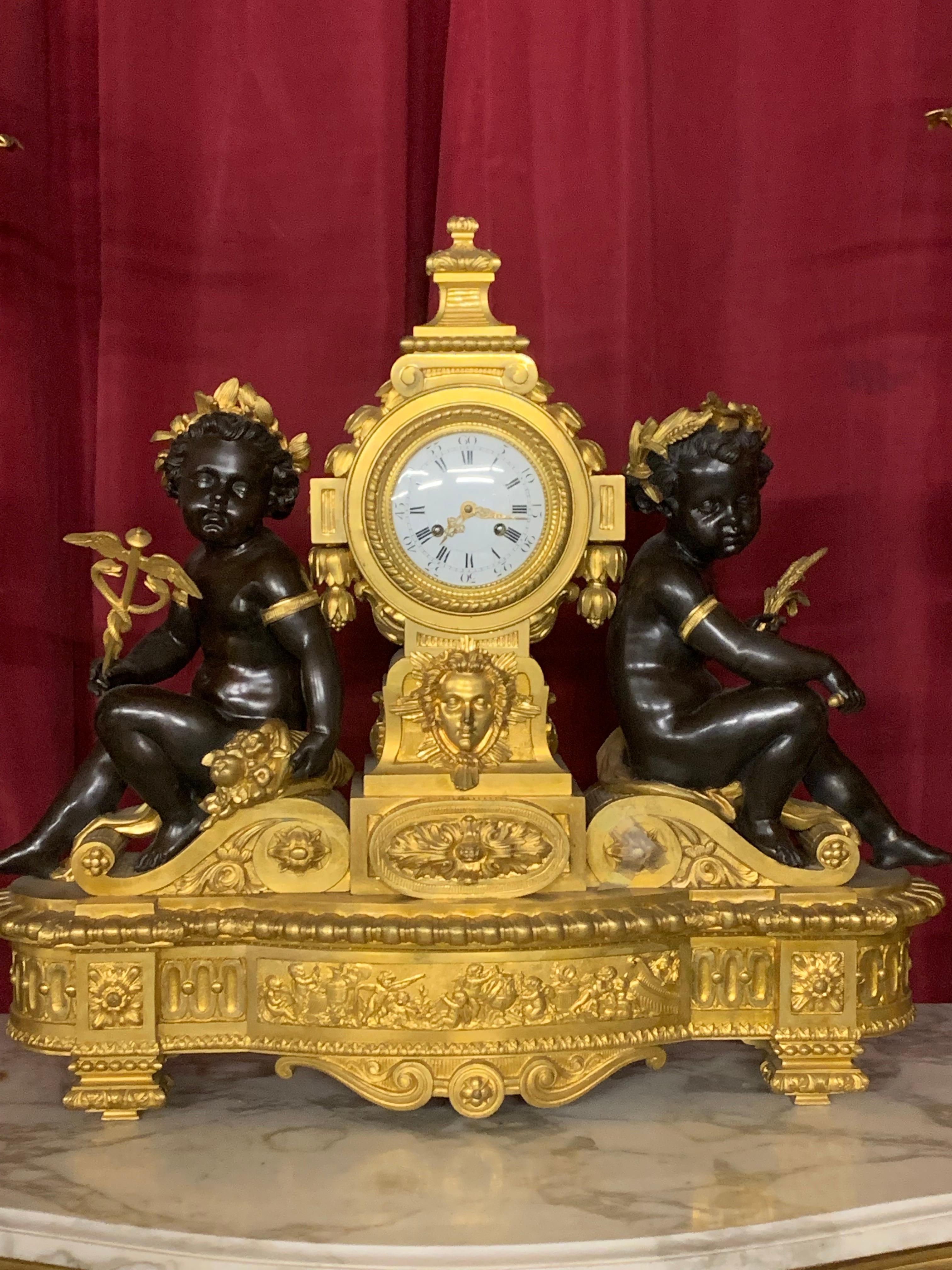 Incredible and huge gilded and patinated bronze clock set of three pieces composed of a pair of  nine lights candelabra and a clock . The candelabra are supported by a two standing cherub, the clock is decorated by two lying  cherub on each side
all
