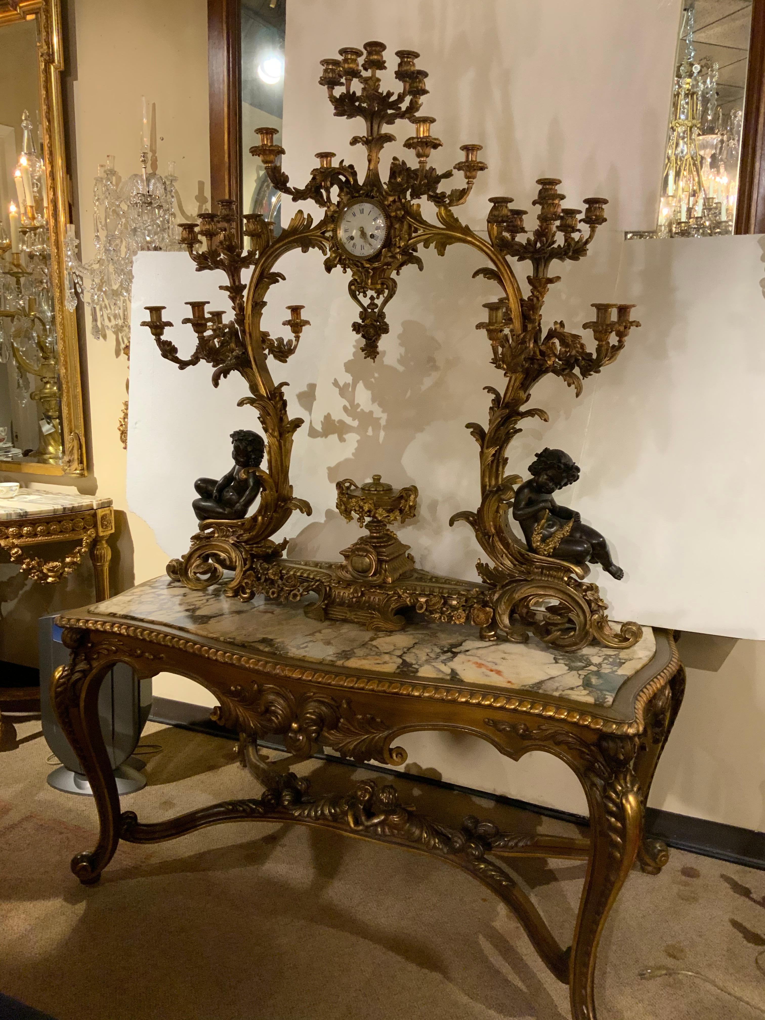 Exquisite and large scale French bronze doré and patinated bronze 
Elements Encase this exquisite clock presentation.
27 candelabra with scrolling arms decorate the entire piece.
The patina is original and brilliant.
This monumental presentation has