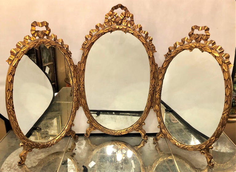 Palatial French Giltwood Triple Oval Shaped Vanity Mirror With Carved Bow Tops