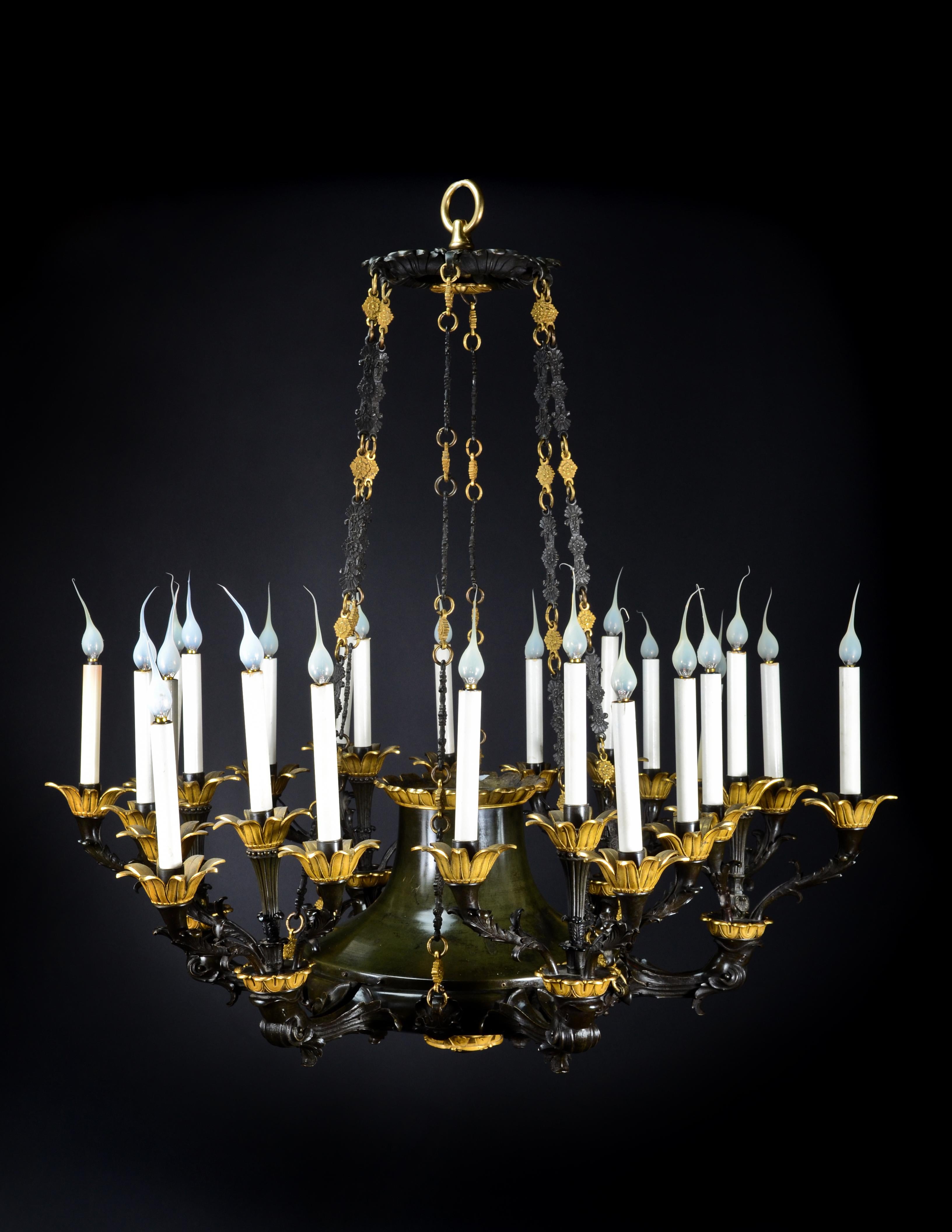 A Palatial and large antique French Empire gilt and patinated bronze multi light neoclassical chandelier of superb quality embellished with patinated bronze arms which are adorned with dolphins.