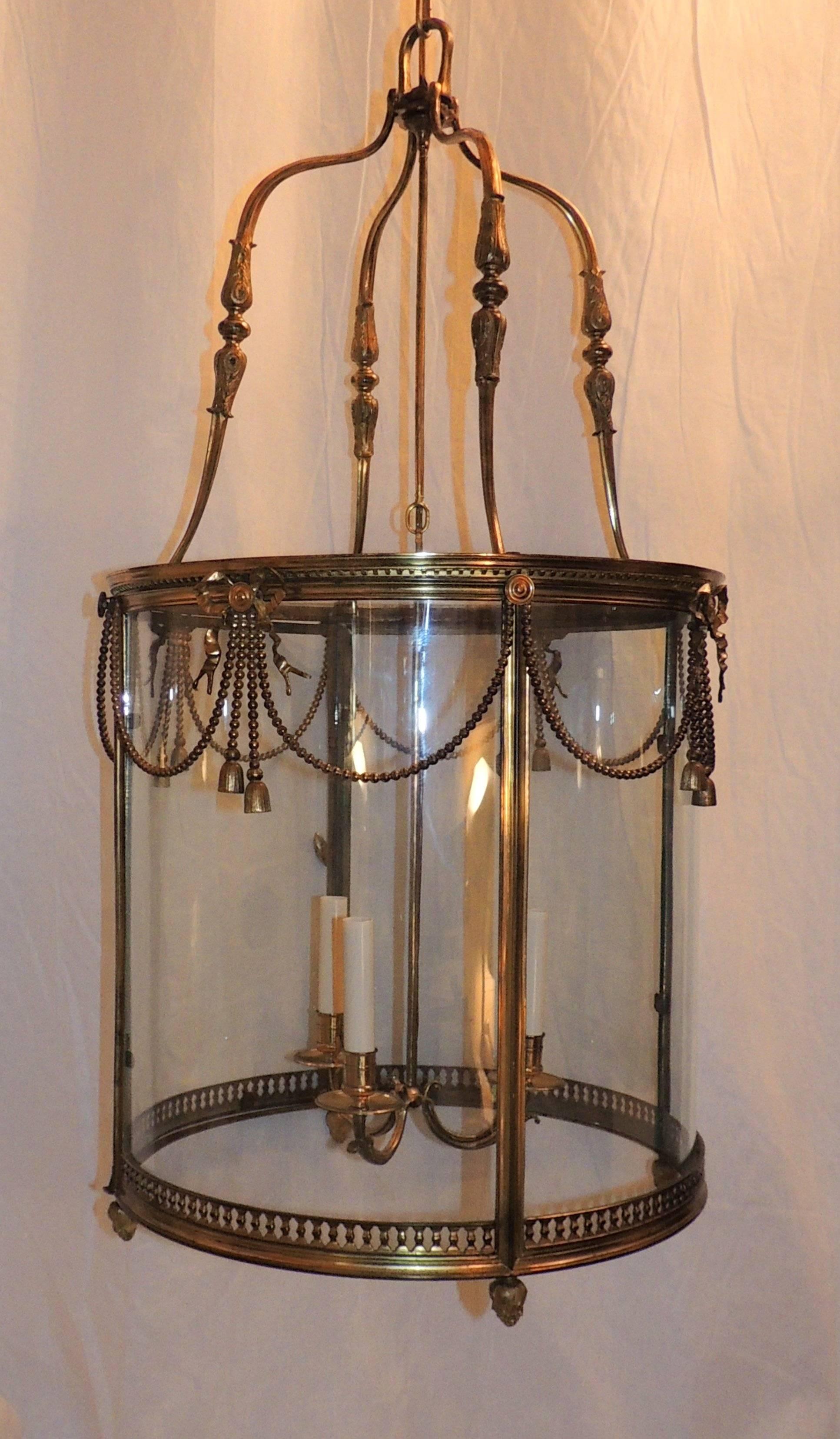 Exquisite French Louis XVI style gilt bronze three-light lantern fixture adorned with bronze beaded swags and finished with a center medallion of a bow.

Measures: 36