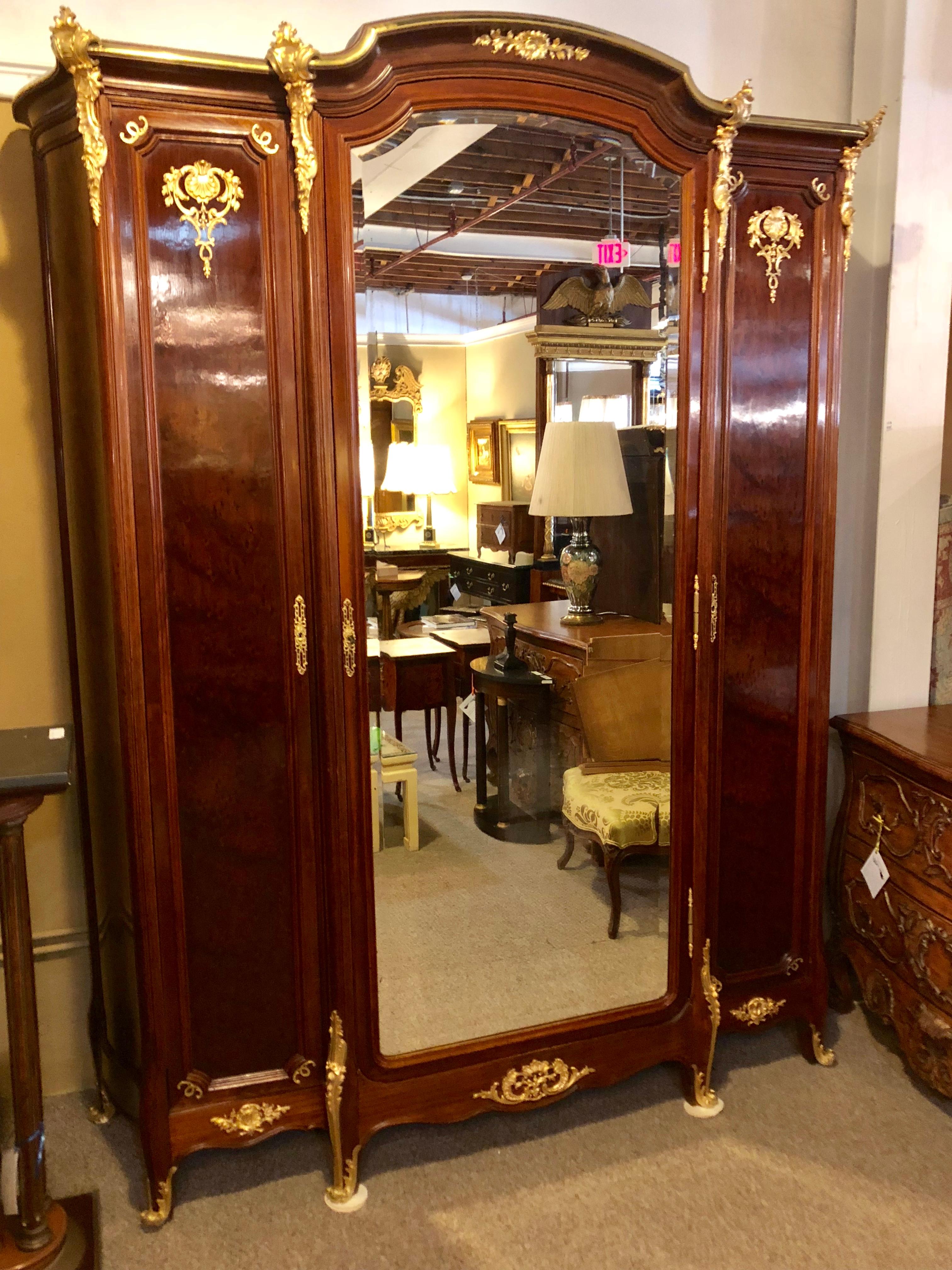 Louis XV spectacular bronze-mounted three-section armoire with interior mirrored doors and bevelled large centre door front. Tortoise shell finish on the front and sides of this fine one of a kind late 19th century armoire or wardrobe chest. Having