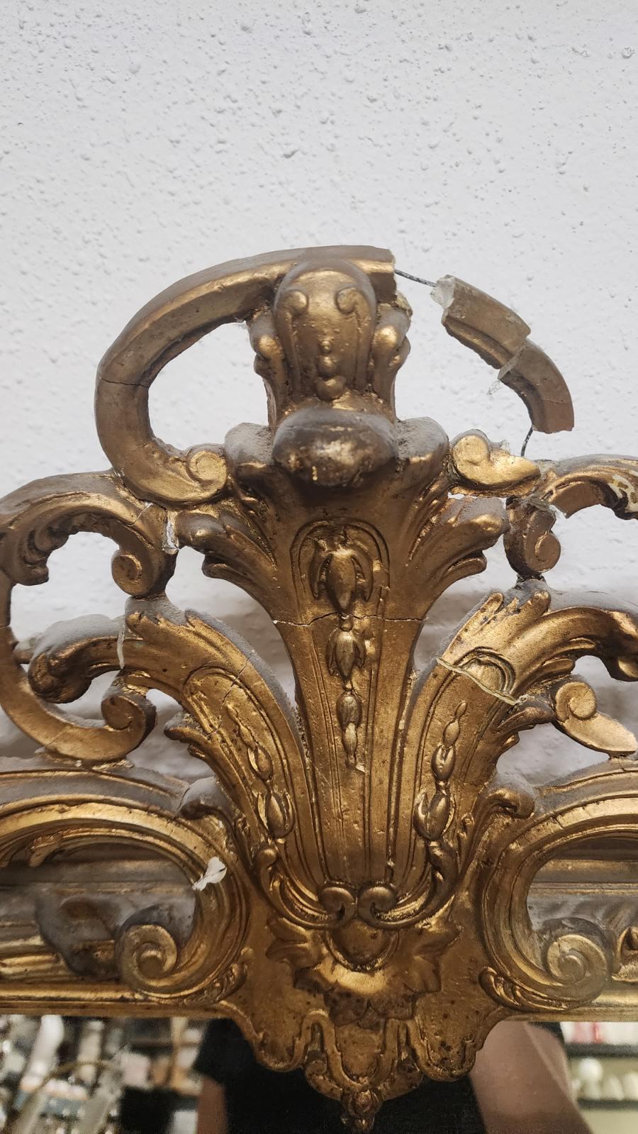 French Louis XV Style mirror. Giltwood, with decorations adorning each side. 