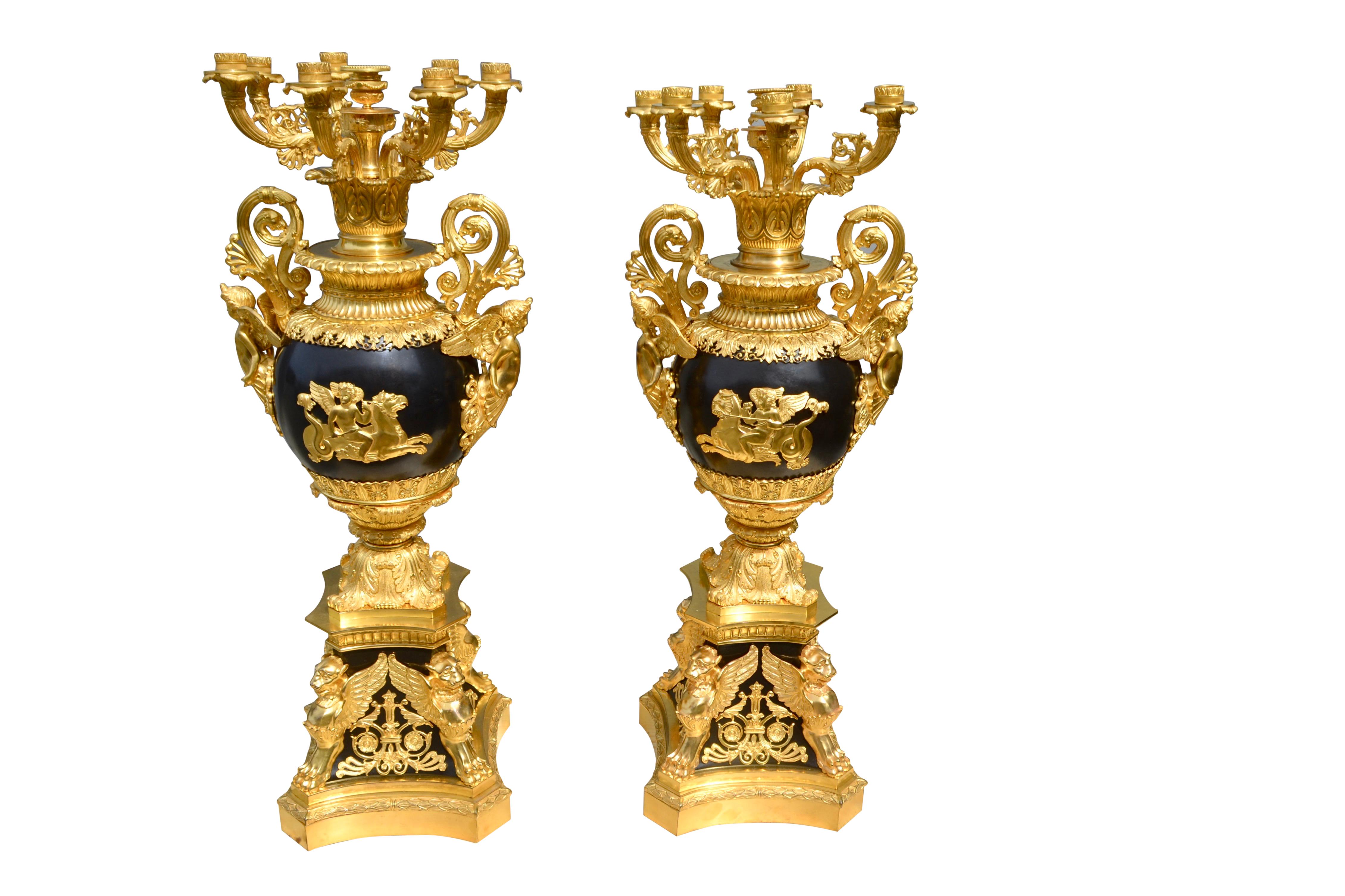 The candelabra are of gilt and patinated bronze of very high quality. They are basically deisgned/constructed in three sections. The middle section; the patinated central vases have twin handles in the form of decorative winged cupids, the front of