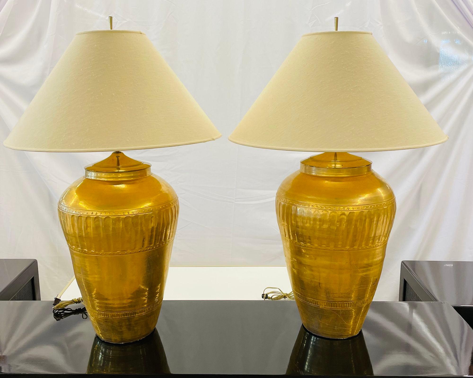Paire de lampes de bureau en forme d'urne en métal doré, style Hollywood Regency
 
Paire de lampes de table monumentales de forme Ginger Jar en métal craquelé doré à l'eau, chacune dotée de deux lampes nouvellement câblées. La paire avec des