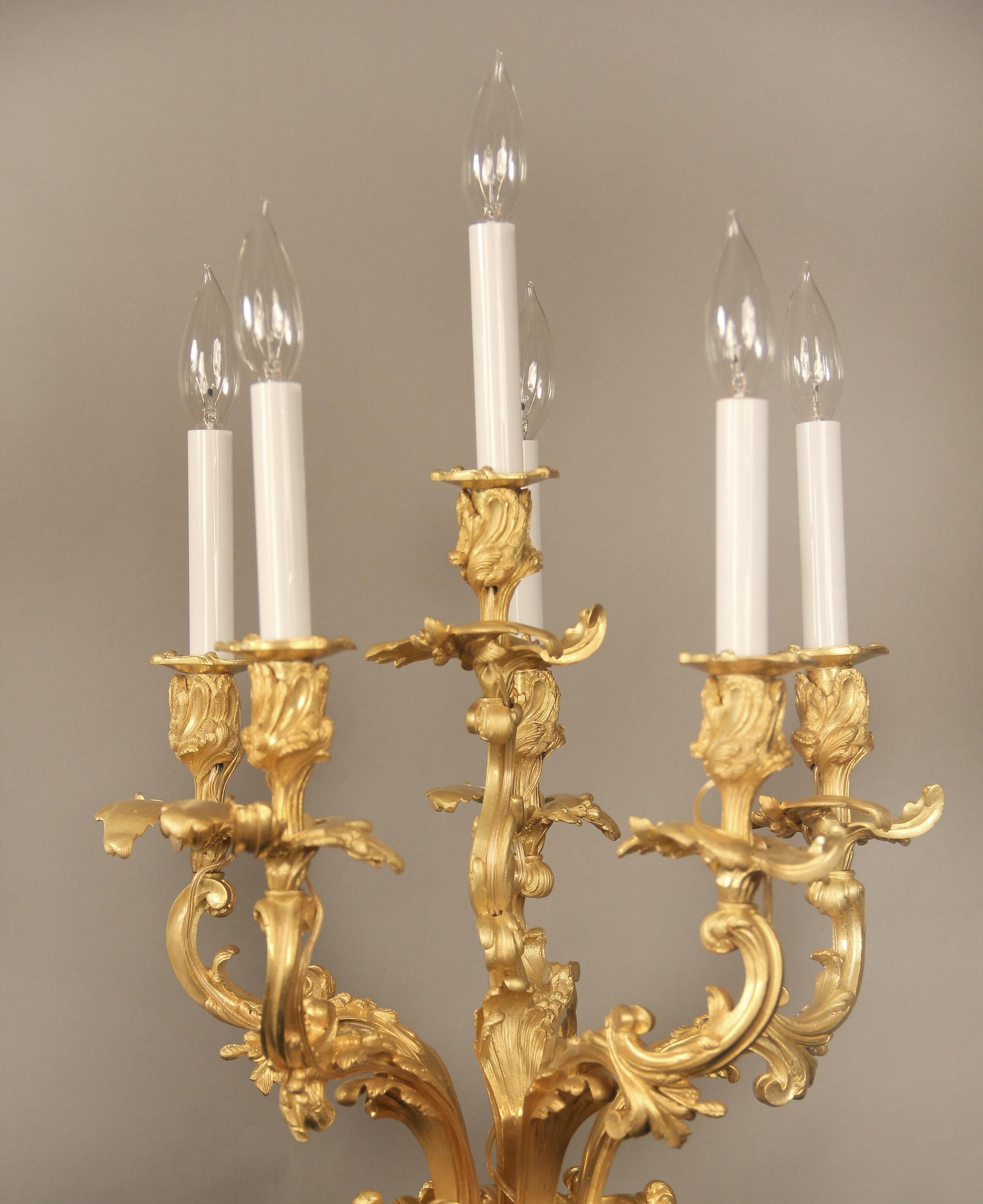 A Palatial Pair of Late 19th Century Gilt Bronze Mounted Six Light Malachite Candelabra

Finely casted gilt bronze and rococo and foliate arms above a spiraled carved malachite body with bronze handles, supported on thick square bases.

Malachite is