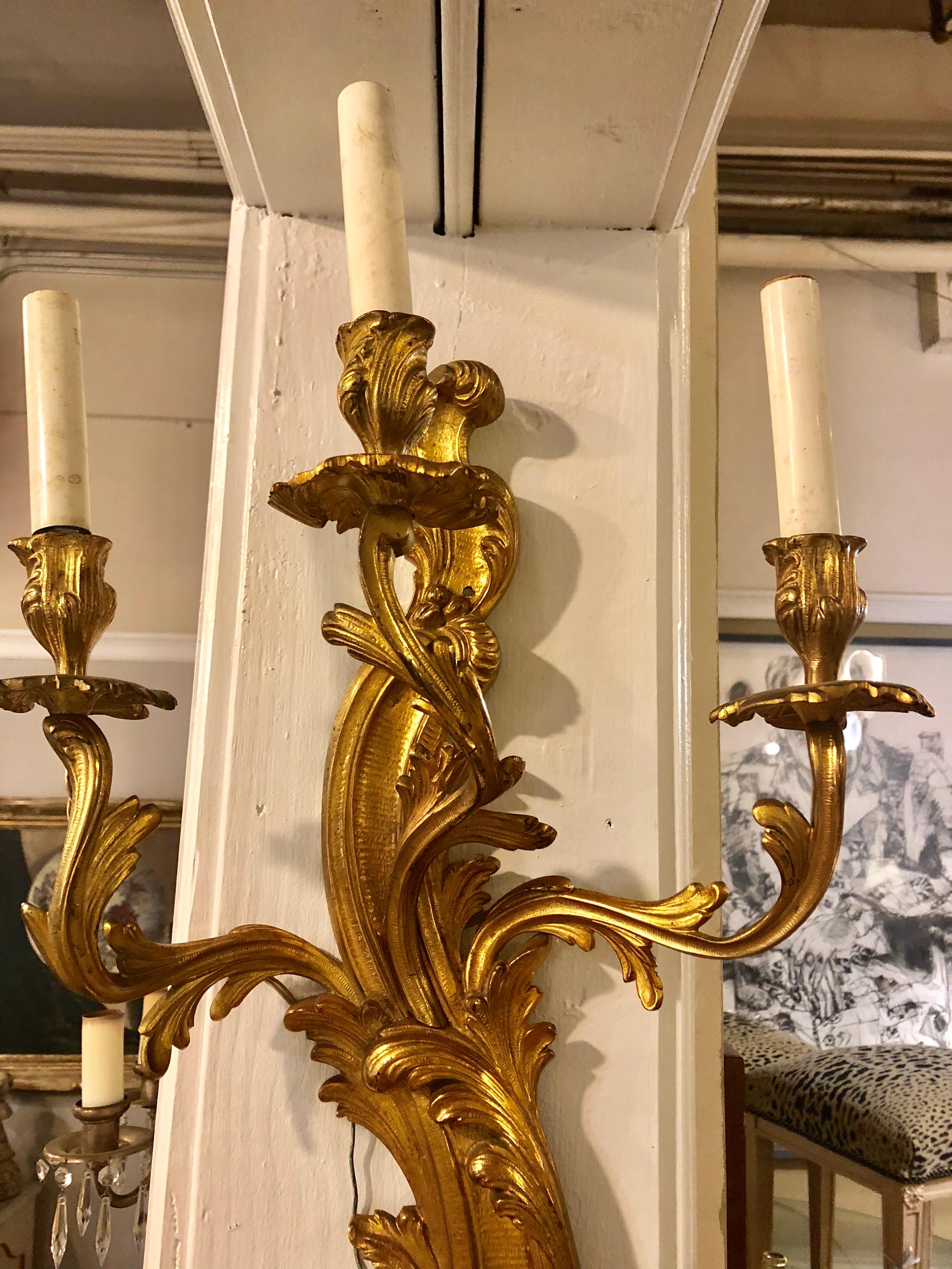 A palatial pair of Louis XVI style eight-arm gilt bronze wall sconces. Having three over five lights. This large and impressive pair of wall sconces date back to the late 19th or early 20th century.