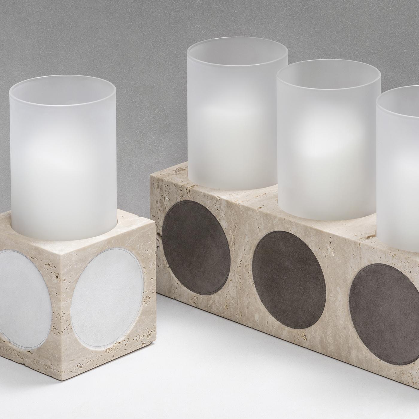 Elegant in its simplicity, this lavish candleholder is the perfect accent in an entry way or living room side table. The square frame, made out of beige travertine limestone, is adorned with large circular inserts in black nappa leather, embedded on