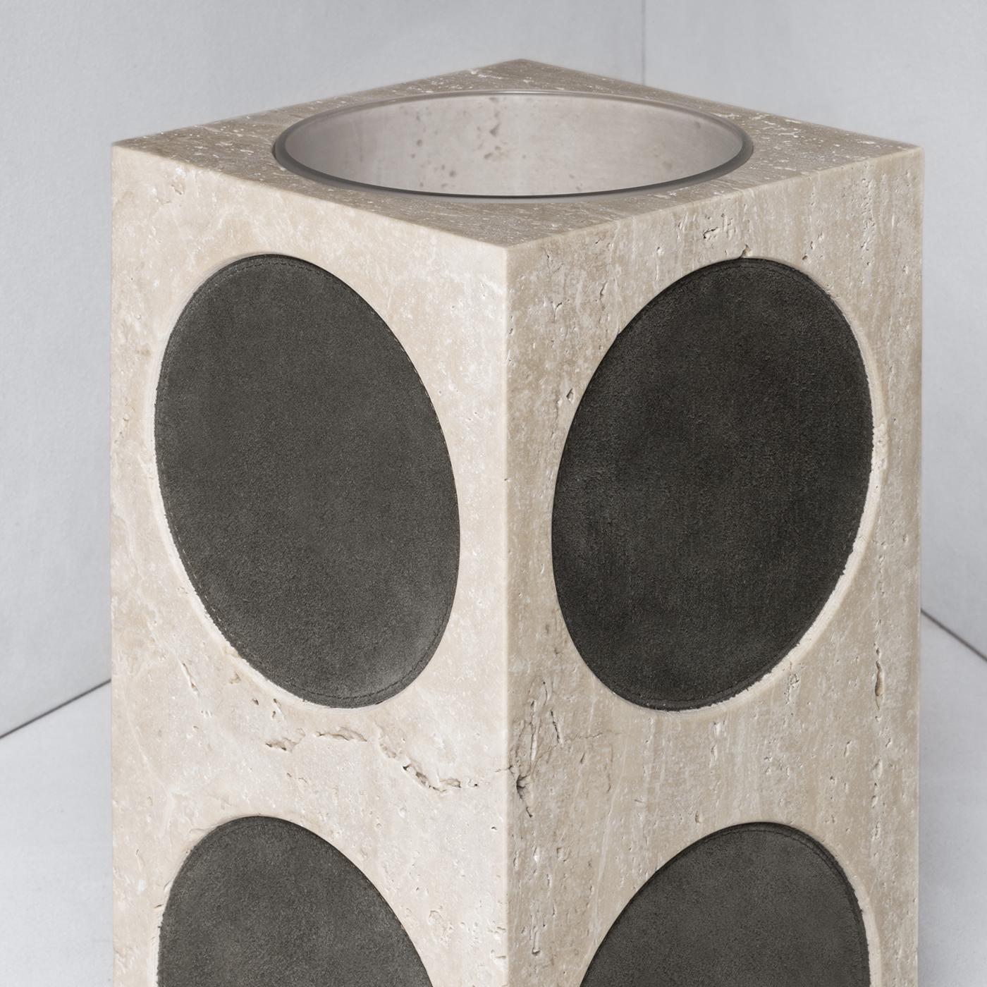 Perfect for flowers, this vase is a sophisticated accent on an entryway console or study desk. Made out of prized travertine beige limestone, the rectangular silhouette of this vase is accented with large circular inserts in black nappa leather on