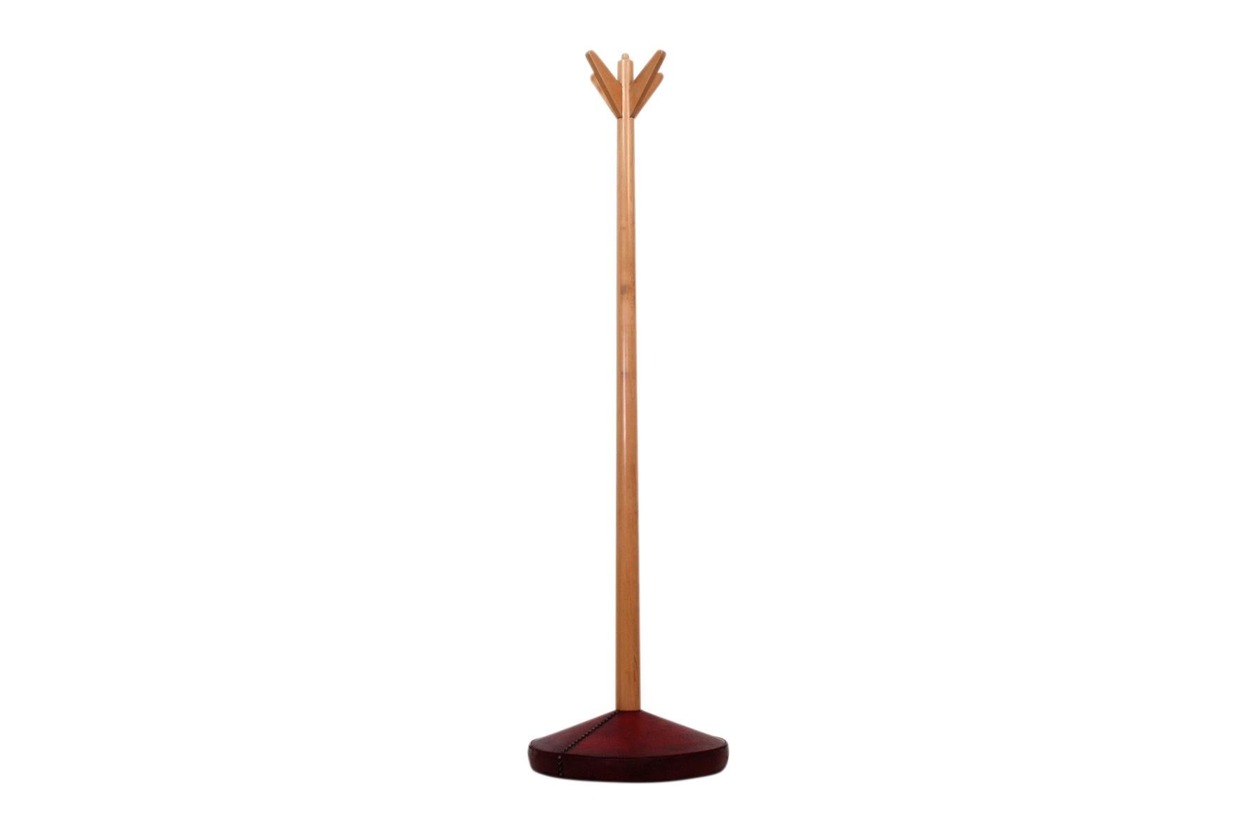 Paldao coat rack by Gilbert Rohde for Herman Miller. Original studded leather base with turned wooden column, circa 1941.
