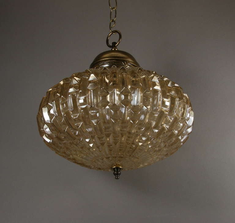 A geometric pattern amber glass single light pendant. Clear glass pendant also available.
