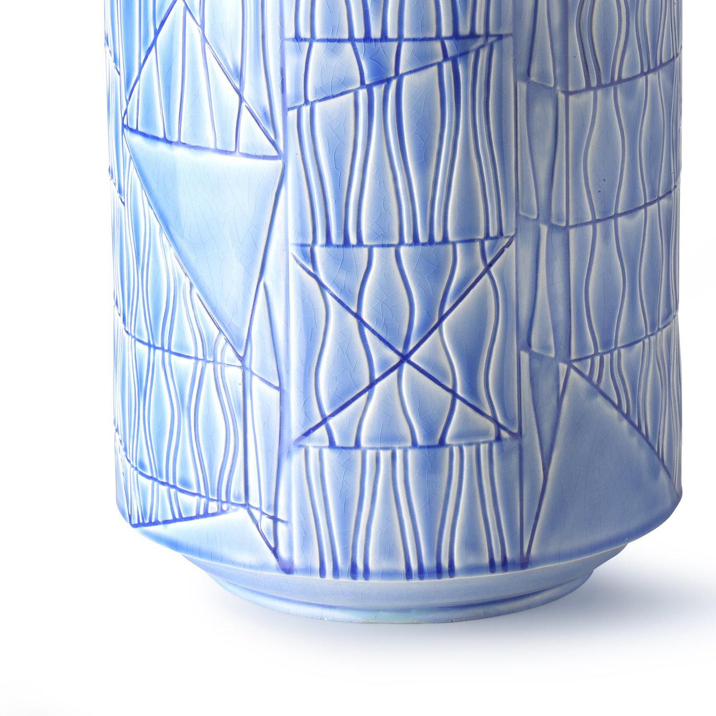 This striking pale blue vase, designed by Bethan Laura Wood in 2016 is in white clay with a delicate pale blue finish and features a large cylindrical body decorated with geometric carvings.