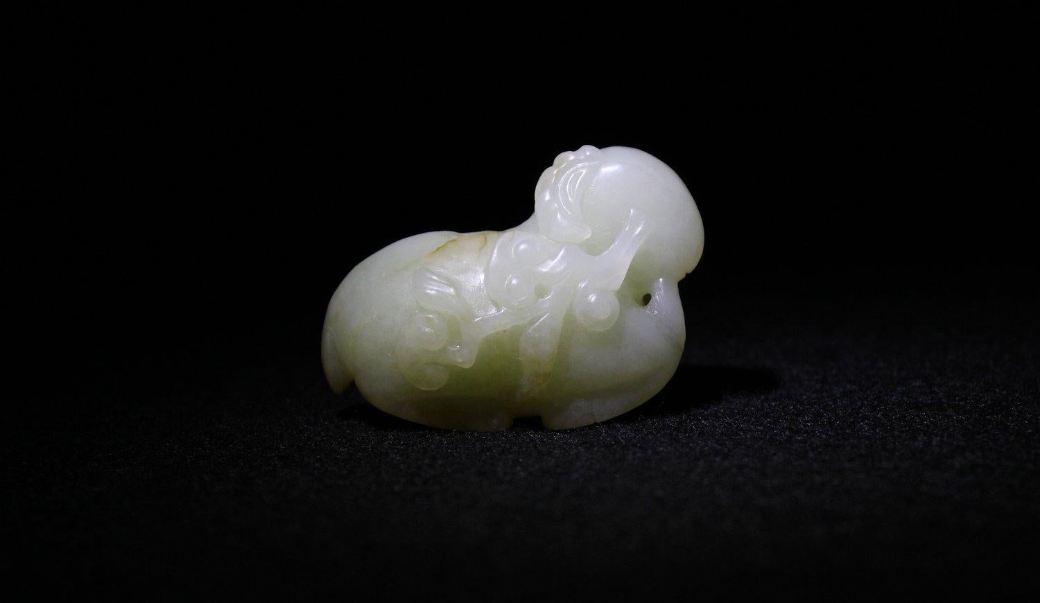 Ce bélier, aux membres repliés en position assise, possède des cornes frisées détaillées et tient dans sa bouche des branches de lingzhi. Les yeux et la bouche sont finement sculptés. Le dos et les pattes sont de couleur rousse.

Le bélier, qui se