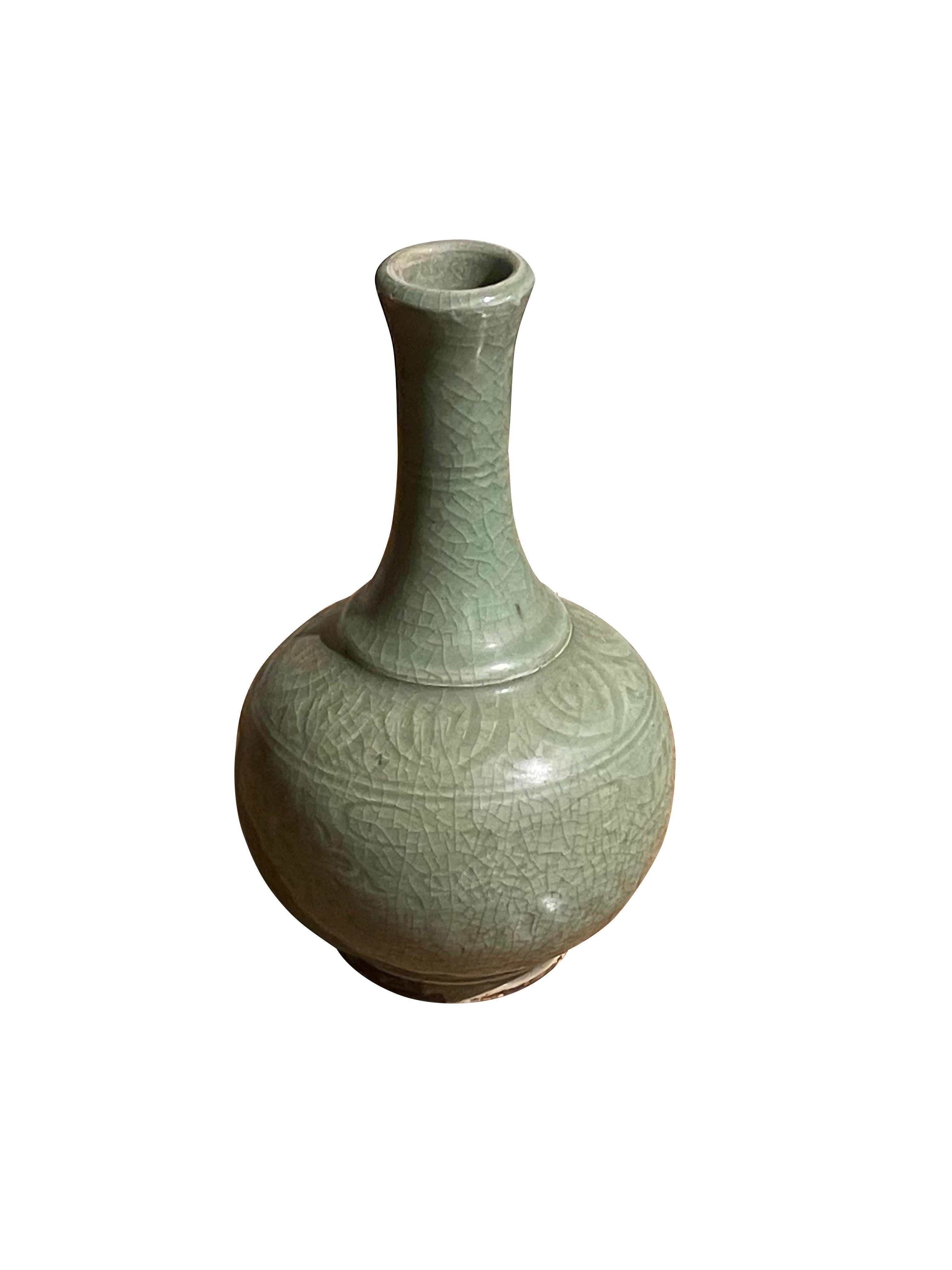 Contemporary Chinese pale celadon vase with decorative surface pattern.
Crackle finish glaze.
Slender neck with small opening.
Rounded base design.
From a large collection.
ARRIVING MARCH