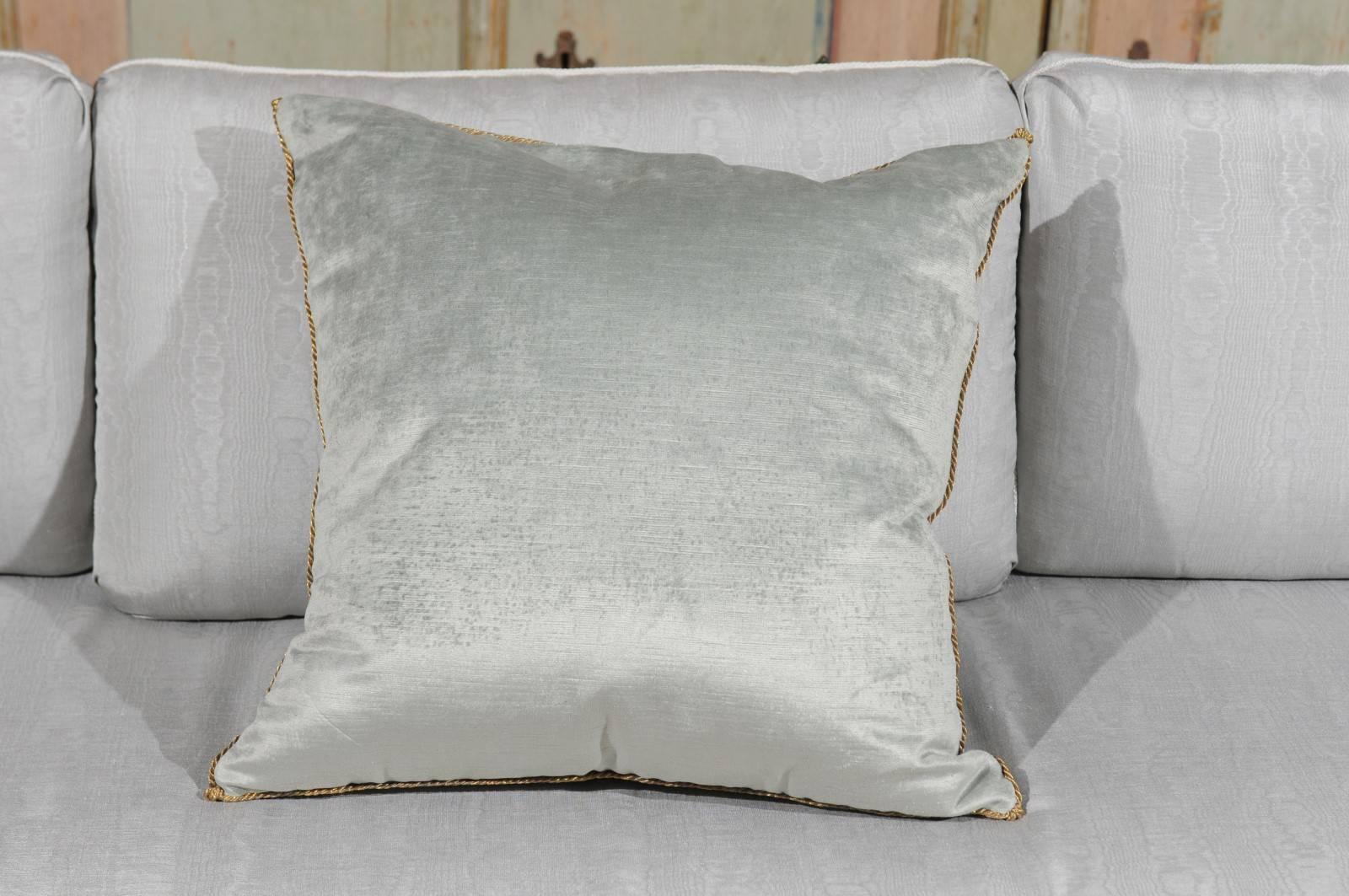 A cushion made of an antique Ottoman Empire raised gold metallic embroidery bordered with antique gold metallic gallon on pale French blue velvet. This down filled square pillow was hand trimmed with a vintage gold metallic cording knotted in the