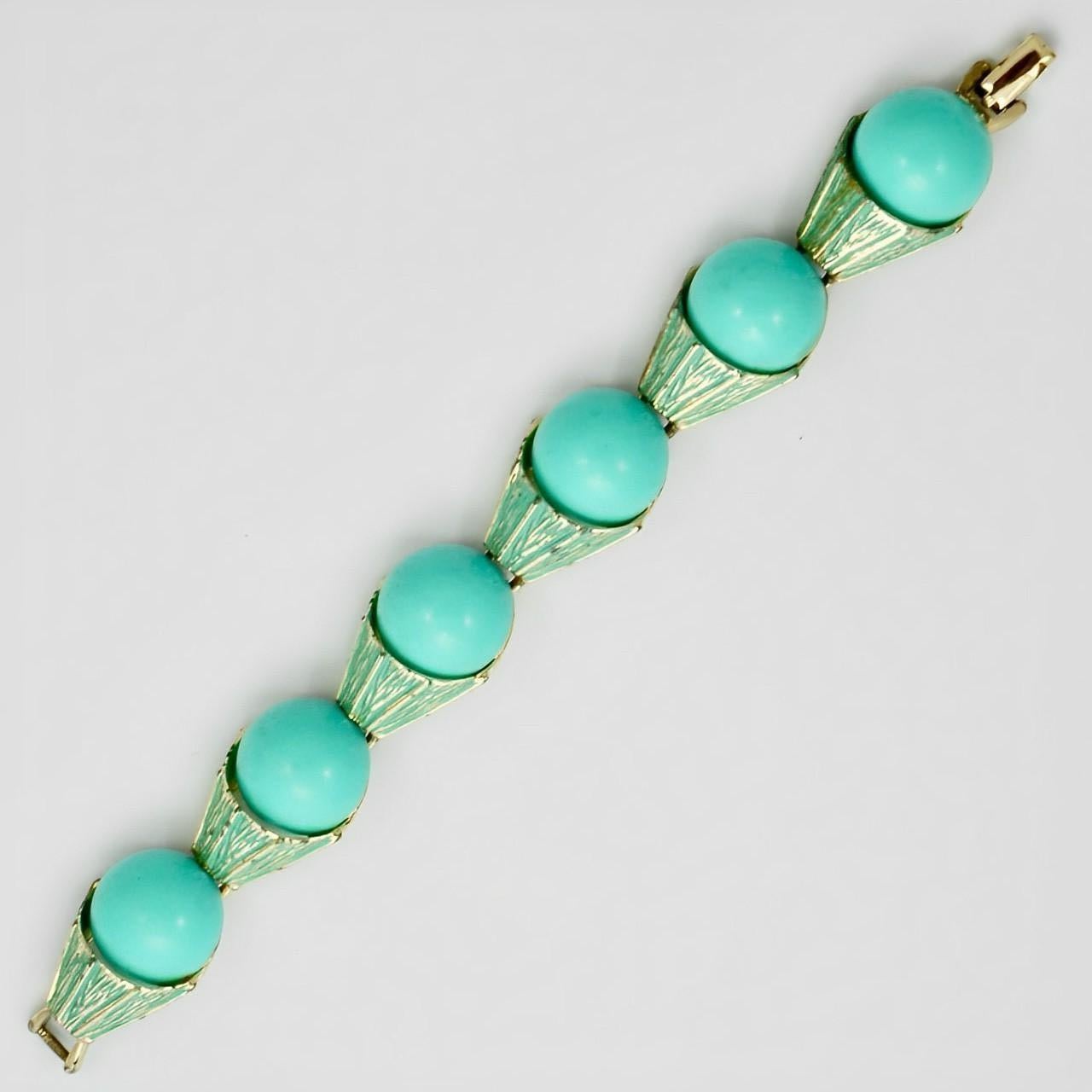 Lovely pale gold tone bracelet, featuring turquoise enamel links set with turquoise lucite domes. Measuring length 18 cm / 7 inches by width 2 cm / .78 inch. There is wear to the gold plating.

This is a stylish and unusual lucite bracelet, a