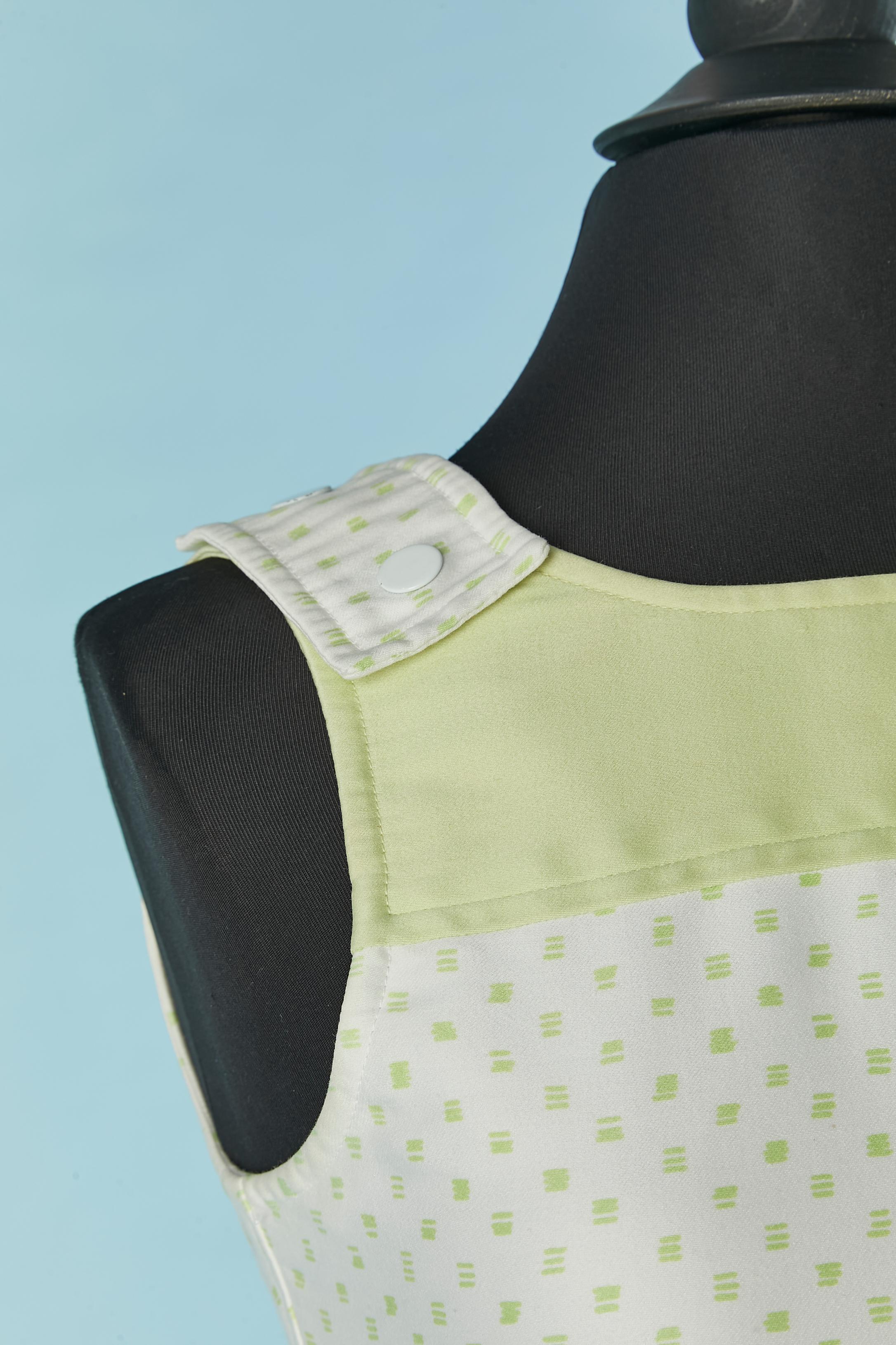 Robe de jour en coton imprimé vert pâle et blanc. Pas de doublure. Fermeture à bouton-pression sur les épaules. Fermeture à glissière et crochet au milieu du dos. Enveloppe sur le devant. Ceinture avec fermeture à bouton-pression sur le milieu du
