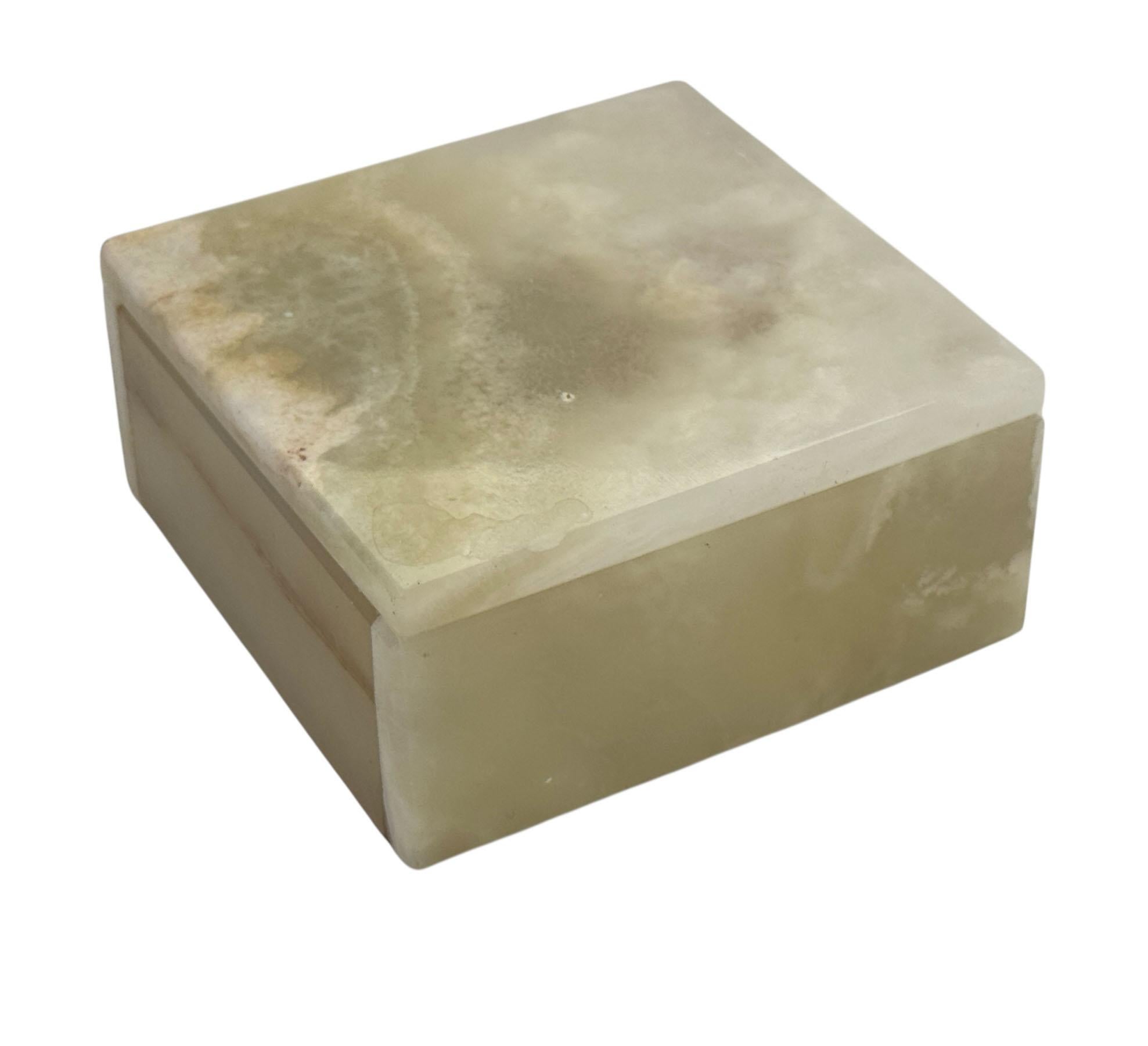 This elegant box is carved from pale green onyx, beautifully accented with natural brown and white inclusions that give it a distinct, organic character. Smooth to the touch with subtle veining throughout, 

it's perfect for storing jewelry,