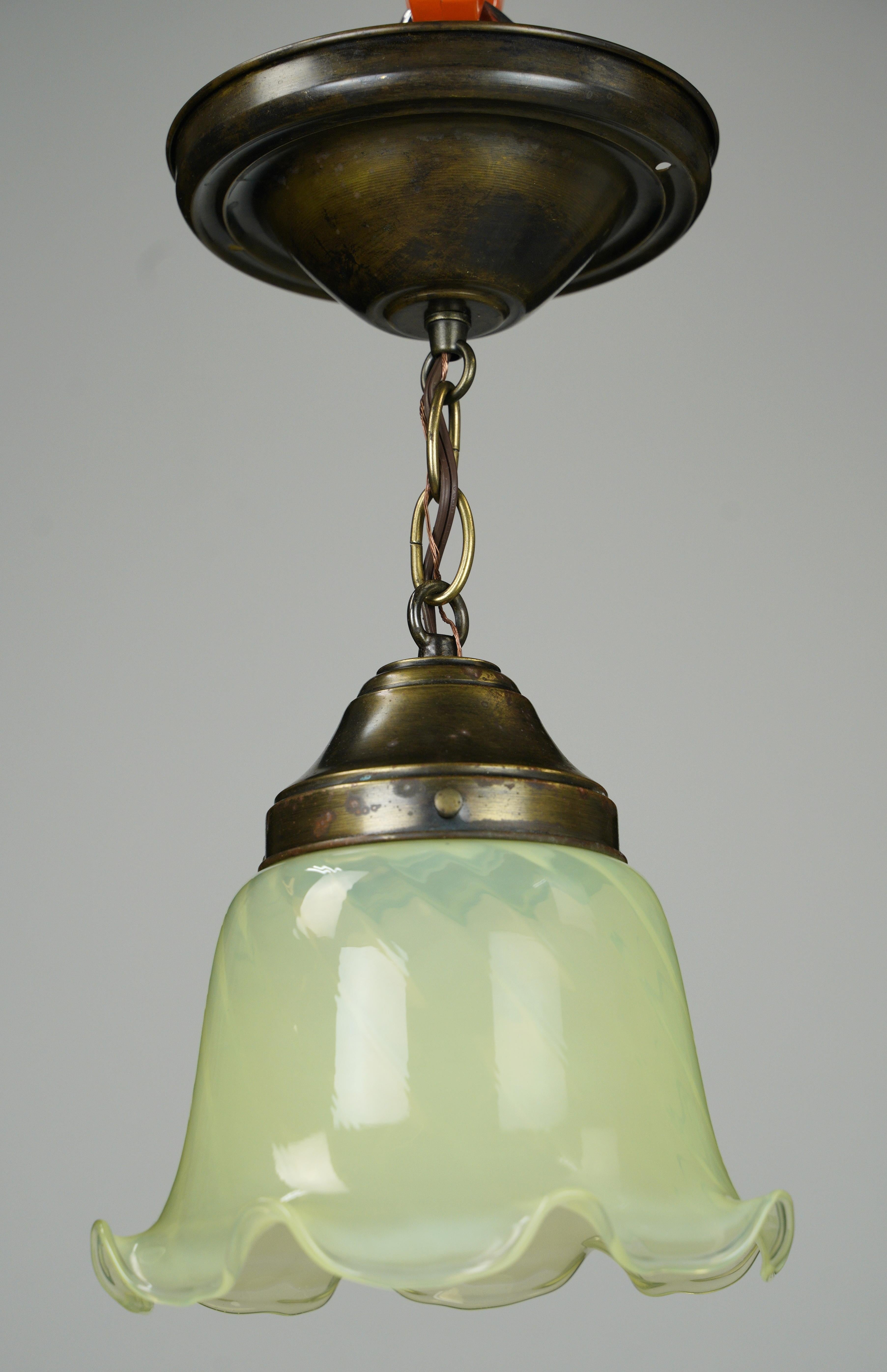 Antique ruffled edge pale green uranium glass shade paired with a newly made antique brass finish chain fitter. This is in very good newly wired condition and ready to install. One available. Cleaned and restored. Please note, this item is located