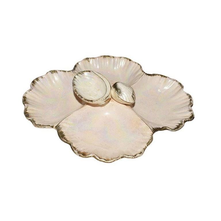 A fabulous pale pink oyster condiment dish or serving platter. Created from ceramic, this dish is glazed in a metallic pink glaze, with hand-painted gold accents. It features four wells, that would be great for presenting sauces or crudités. A