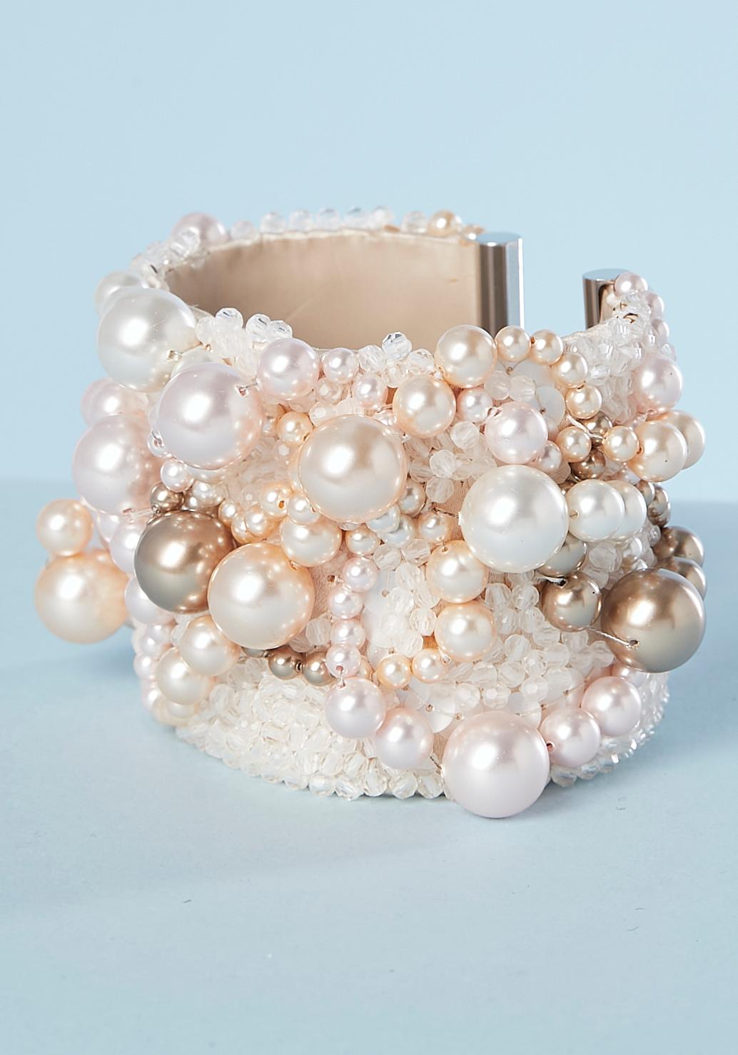 Pulsera brazalete de cuentas rosa pálido con forro de cuero beige y borde metálico. 
Ancho de la pulsera = 5 cm