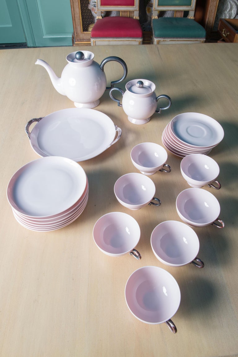 Tea set marked Johann Haviland Bavaria  30140 41. Seven cups and saucers, seven dessert plates, one serving plate, teapot with lid, and sugar bowl with lid.
Set is pale pink with silvery grey accents. Some grey accents are worn. Serving plate is