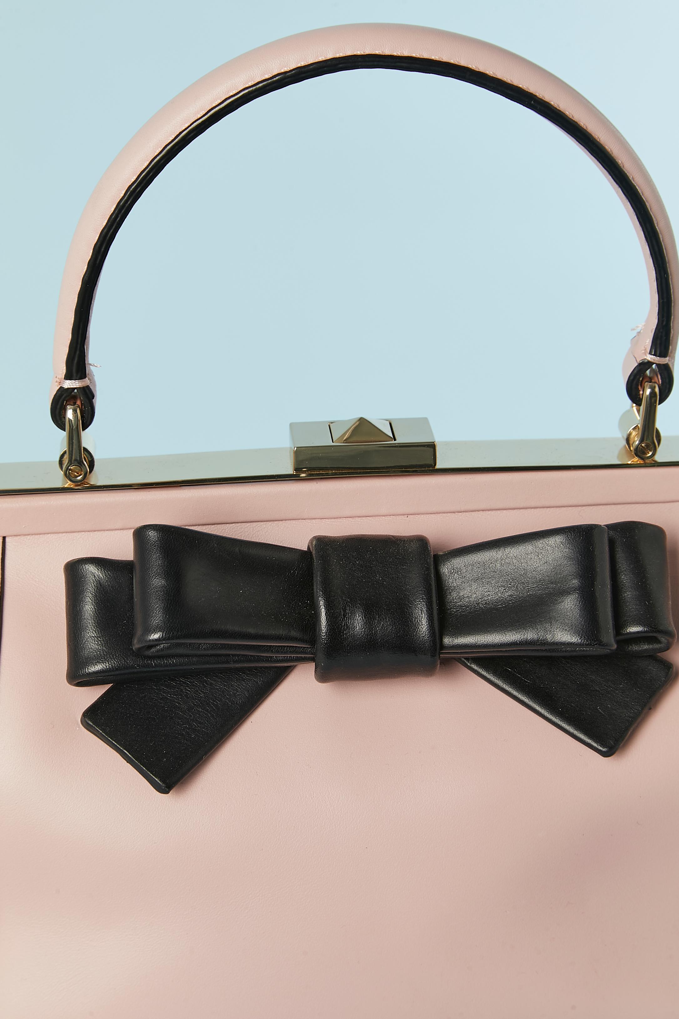 Pale pink leather top handle bag with black leather bow. Polyester lining. 
SIZE : 24cm X 15cm X 9 cm 
Lenght of the top handle : 30cm 
Gold metal hardware