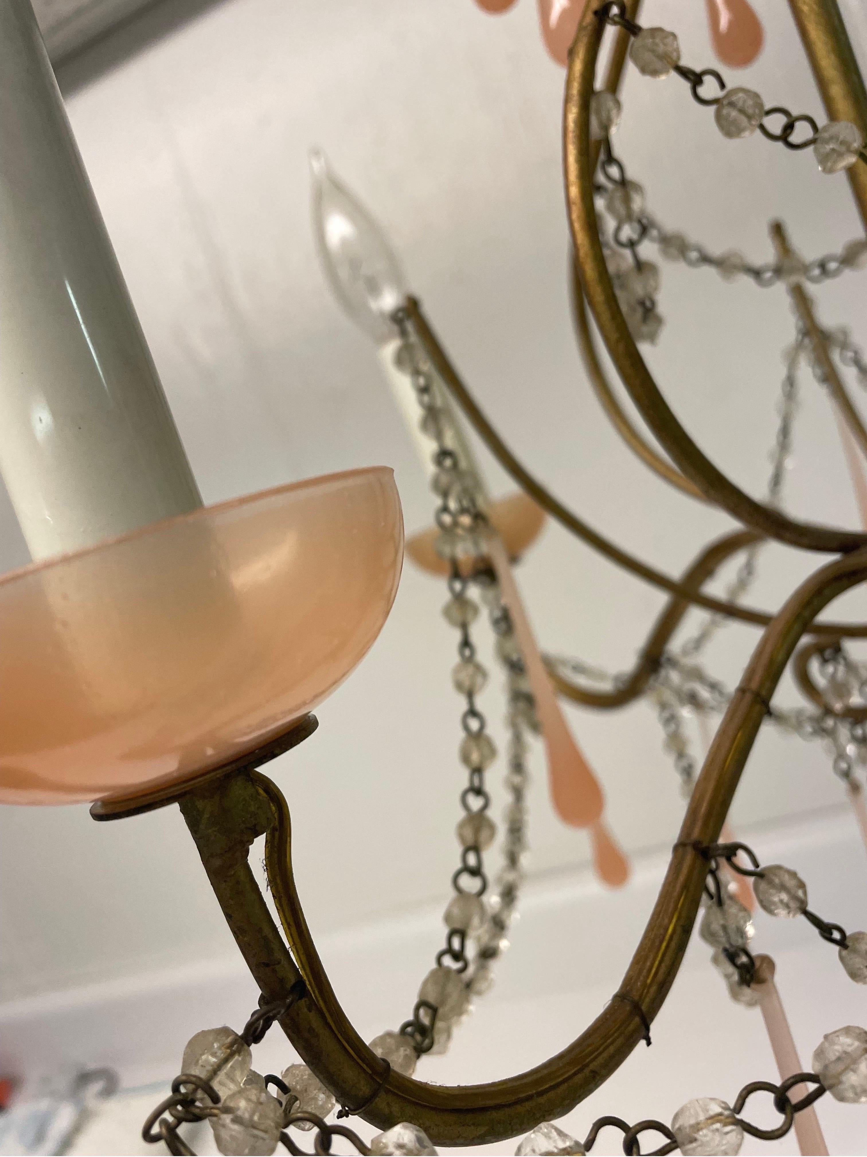 This is a beautiful pale pink drops and crystal noodle vintage gilt metal four arm chandelier.
It is in excellent vintage condition with no cracks or chips . Probably from the 1960s 