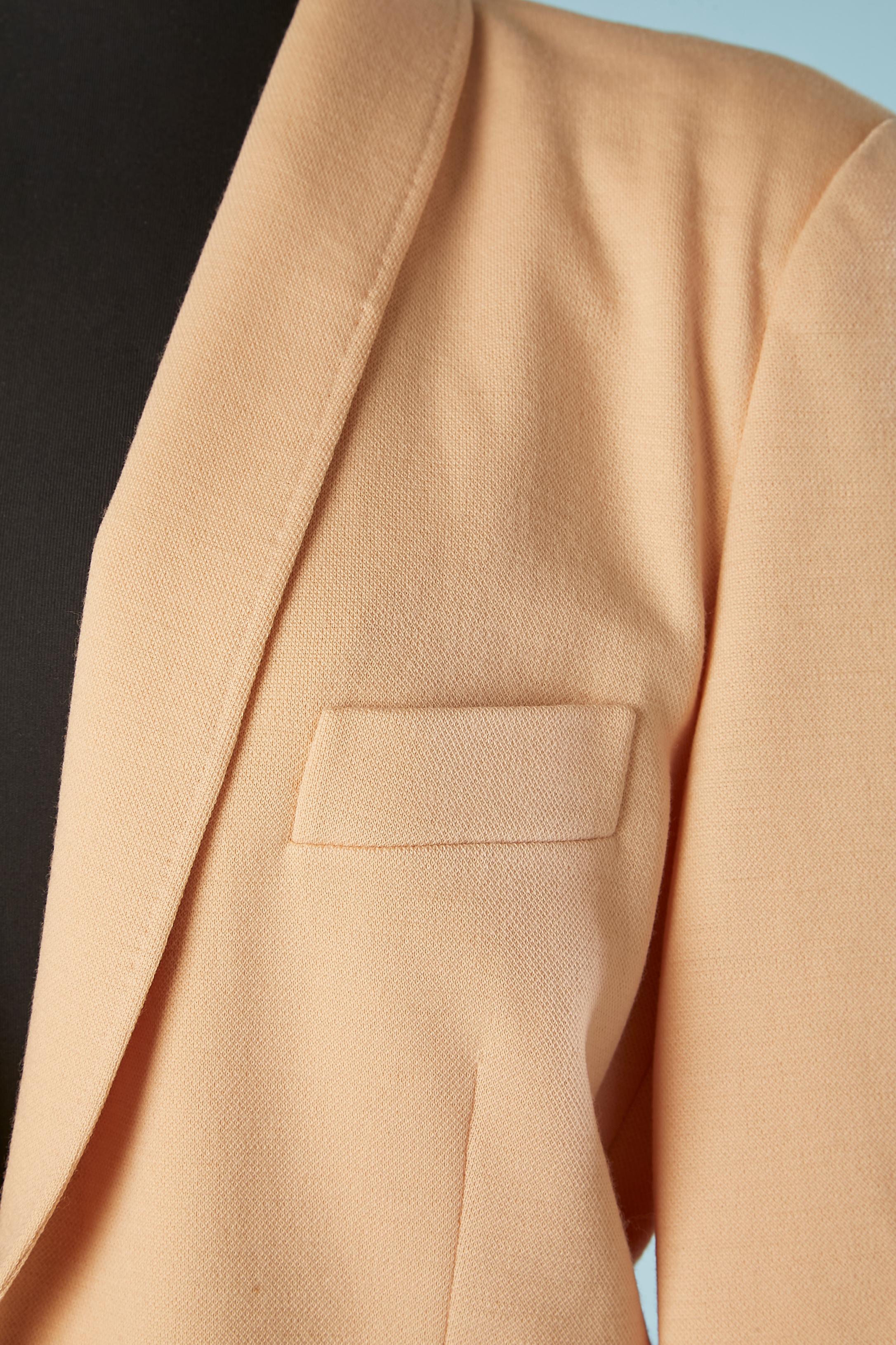 Pale pink wool jersey skirt-suit. no fabric composition information for the lining but probably rayon. 
Asymmetrical collar. One button end buttonhole closure in the middle front and buttons and buttonholes on the cuffs. 
Shoulder-pad. One inside