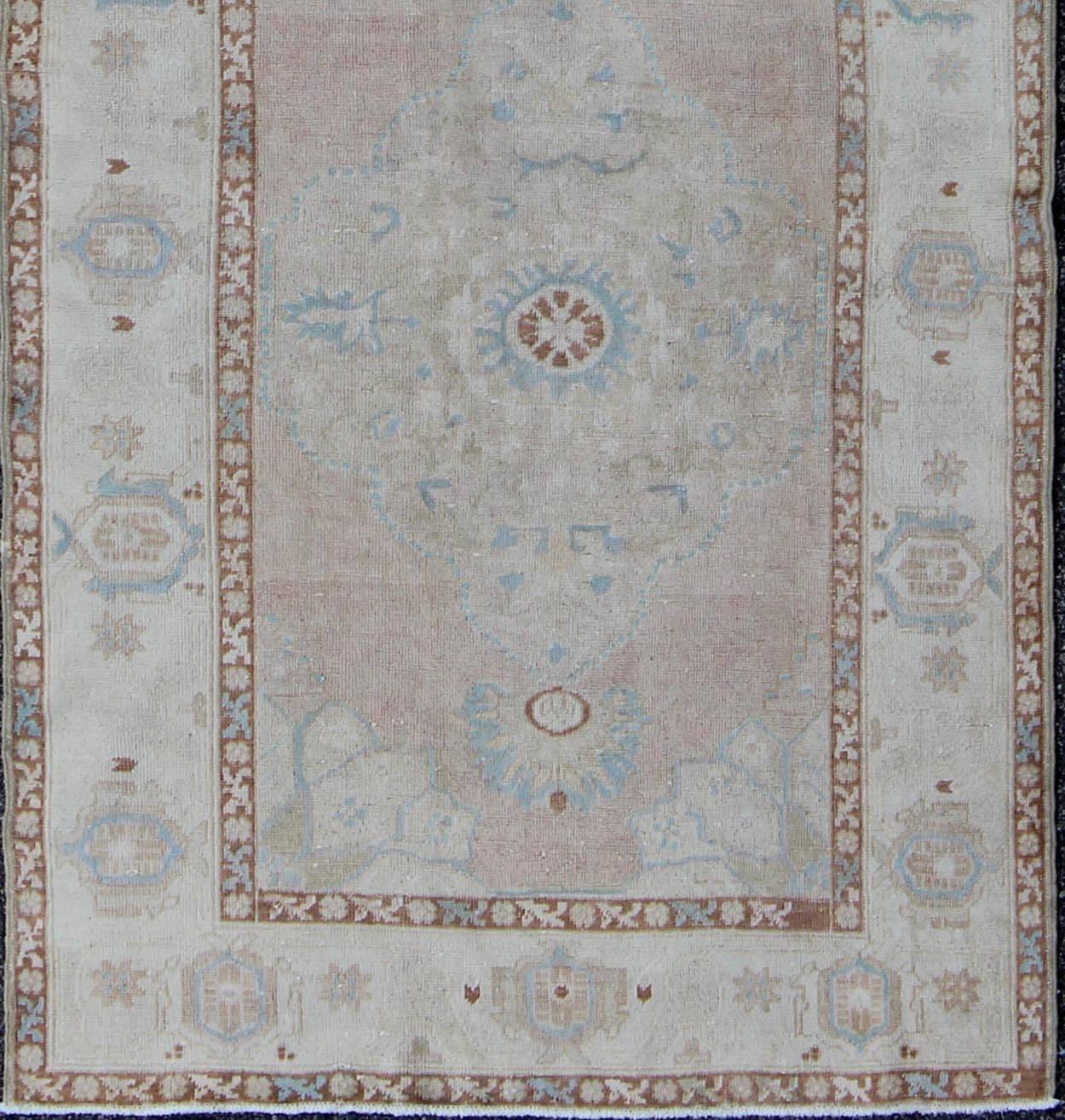 Pale pink, teal and ivory vintage Turkish Oushak runner with three medallions, rug na-63085, country of origin / type: Turkey / Oushak, circa 1930

This beautiful vintage Oushak runner from early 20th century Turkey features a classic Oushak