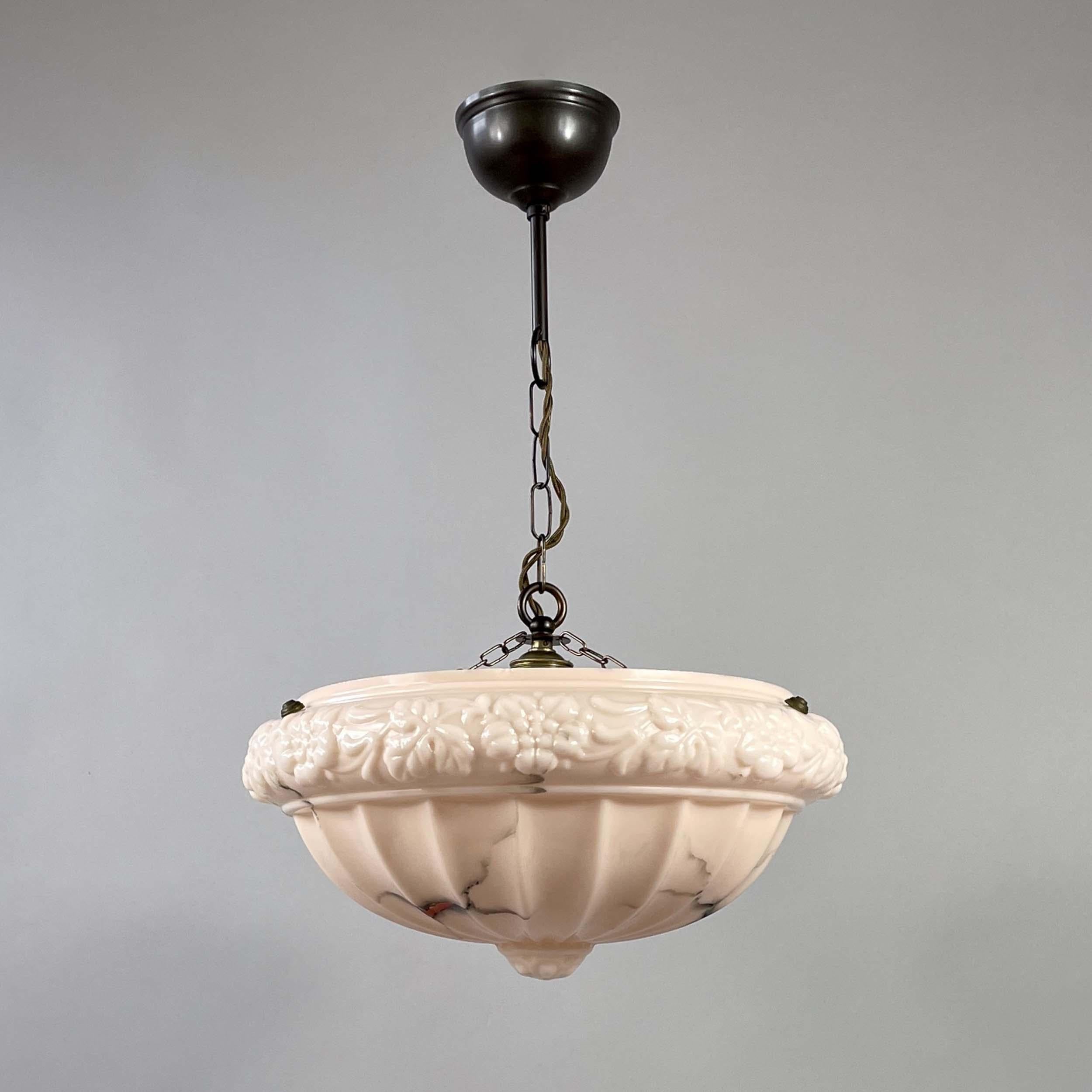 Esta elegante luminaria se diseñó y fabricó en Suecia entre los años 1920 y 1930, durante el periodo de la Gracia Sueca.

La lámpara presenta una pantalla de cristal en forma de cuenco suspendido en un suave tono rosa alabastro pálido con un sutil