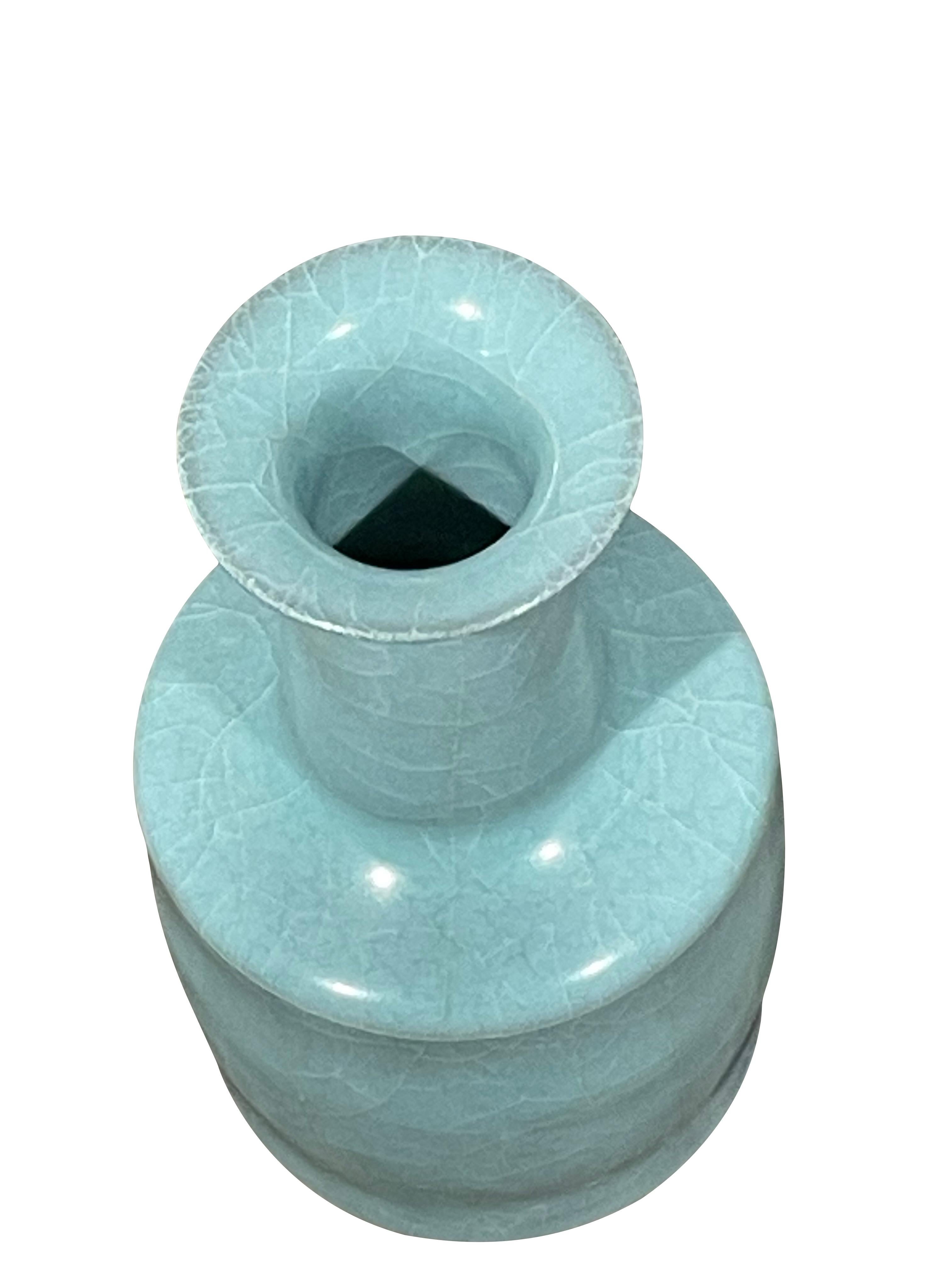 Vase contemporain chinois de couleur turquoise pâle.
Glace craquelée non contrastée.
Un exemplaire parmi d'autres d'une grande collection.
Le sommet est en forme de coupe avec un col en entonnoir et le fond en forme de bouteille.
