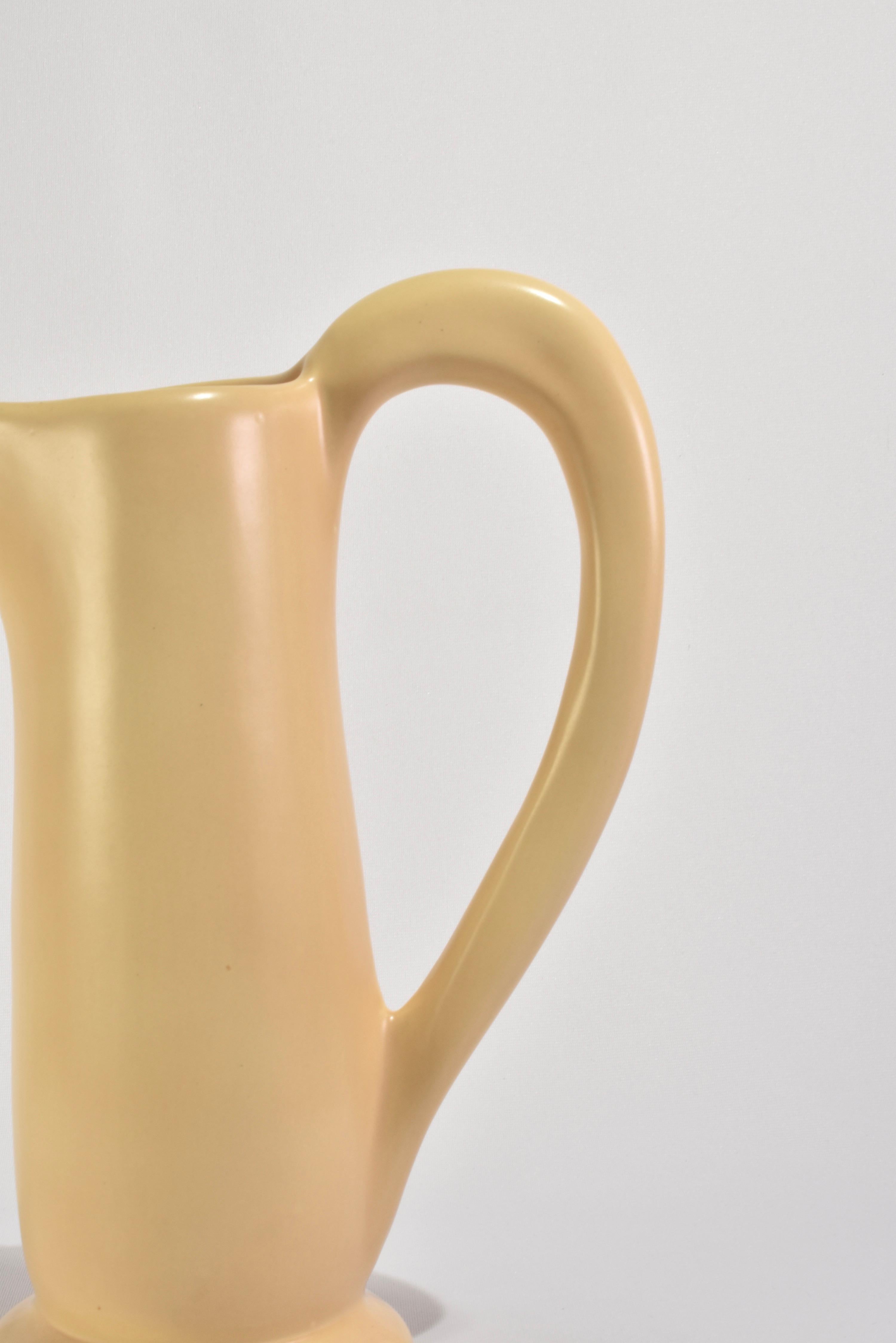 Oversized, vintage ceramic pitcher in a beautiful pale yellow with a large sculptural handle. Signed on base, Cyclamen.