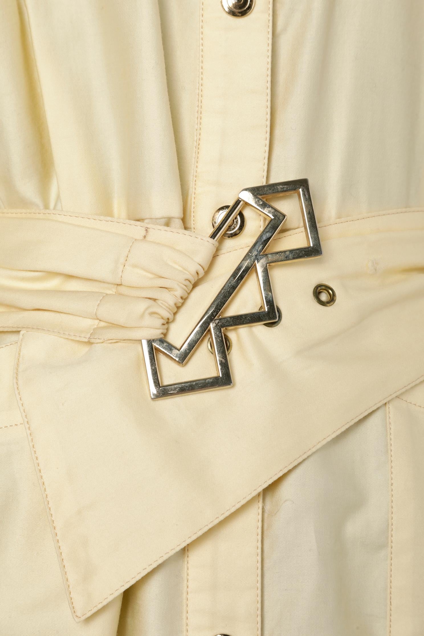 Robe en coton jaune pâle avec ceinture en tissu et boucle. Fermeture à bouton-pression sur le milieu du devant. 4 poches sur le devant. Enveloppée et plissée au milieu du dos. 
TAILLE 38 (Fr) M 
PAS D'ÉTIQUETTE DE MARQUE 