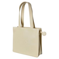 Pale yellow leather hand bag with embossed "Double C" and Camelia Chanel Number